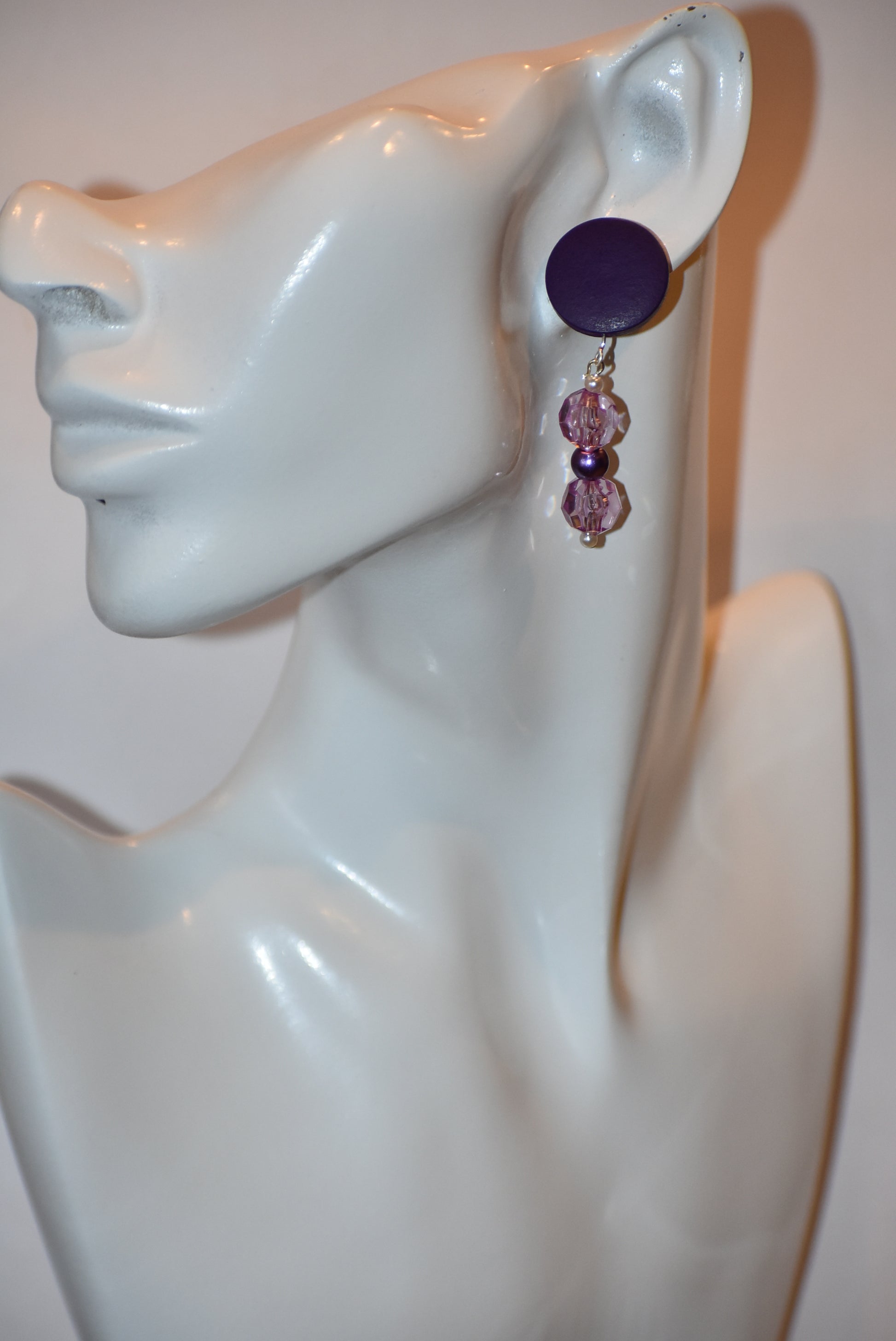 "Looking for something unique and fun? The Purple Collection is a one-of-a-kind piece featuring dark purple posts adorned with pretty purple beads and pearls. Stand out and add a playful touch to your accessory game with this quirky addition!"