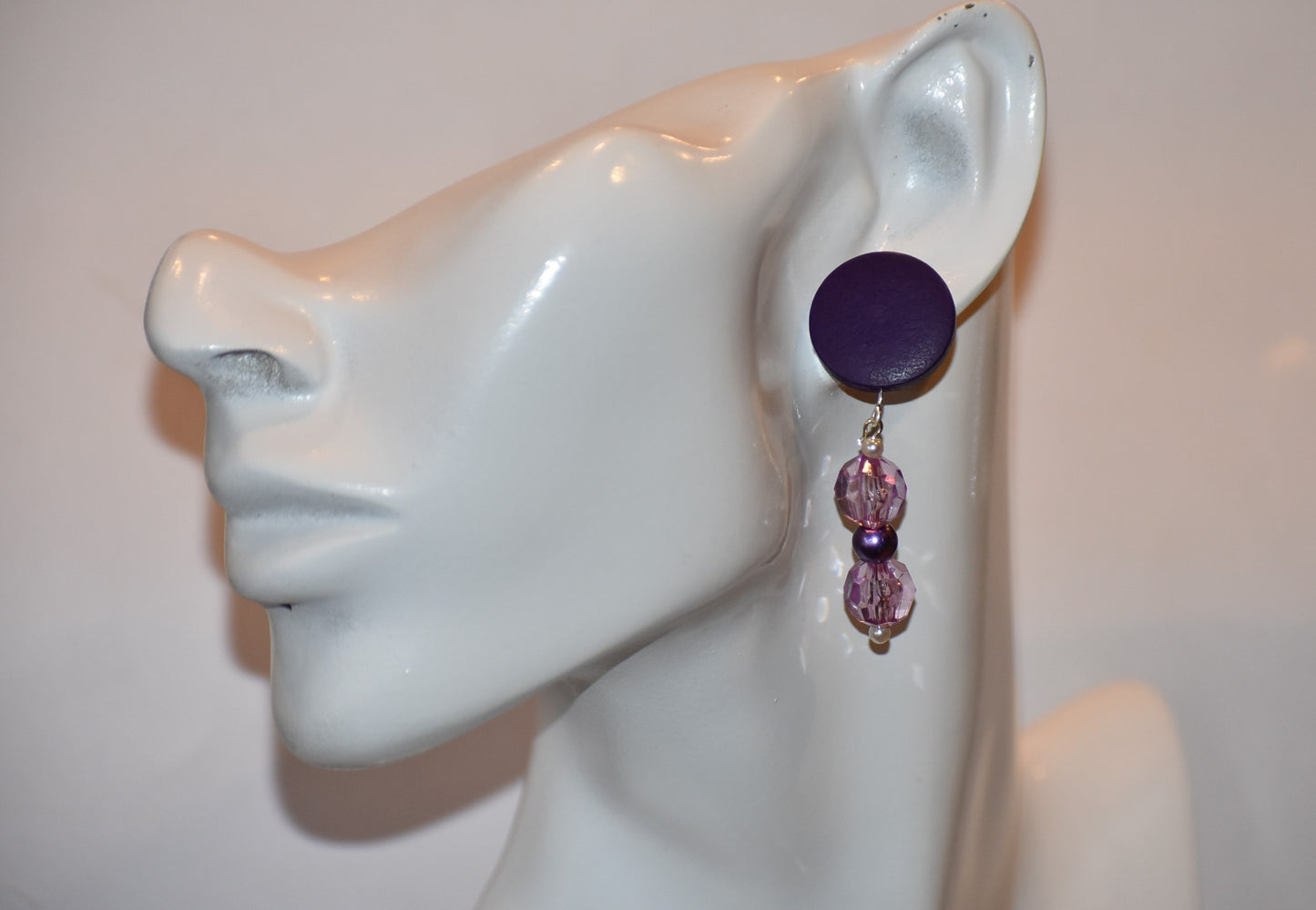 "Looking for something unique and fun? The Purple Collection is a one-of-a-kind piece featuring dark purple posts adorned with pretty purple beads and pearls. Stand out and add a playful touch to your accessory game with this quirky addition!"