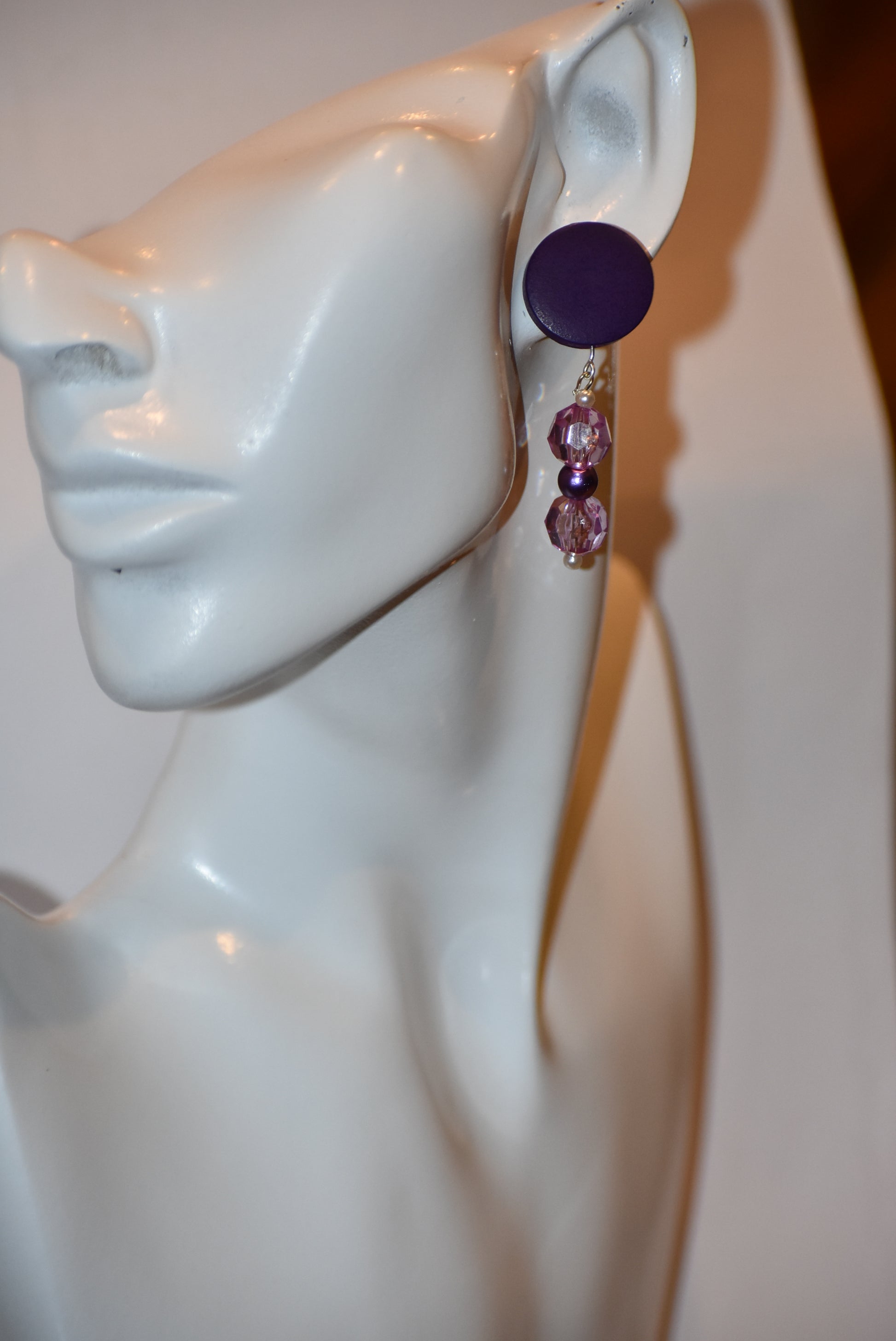 "Looking for something unique and fun? The Purple Collection is a one-of-a-kind piece featuring dark purple posts adorned with pretty purple beads and pearls. Stand out and add a playful touch to your accessory game with this quirky addition!"