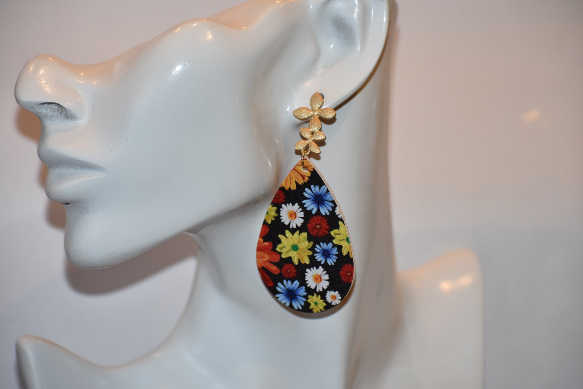 Add a pop of color and quirkiness to any outfit with our Key West Collection earrings! The super fun and bright design features a black background with a vibrant, multi-colored flowered pattern. The unique gold posts add a touch of whimsy, making these earrings truly one-of-a-kind. Get ready to fall in love with these unique flower posts!" 🌺💛