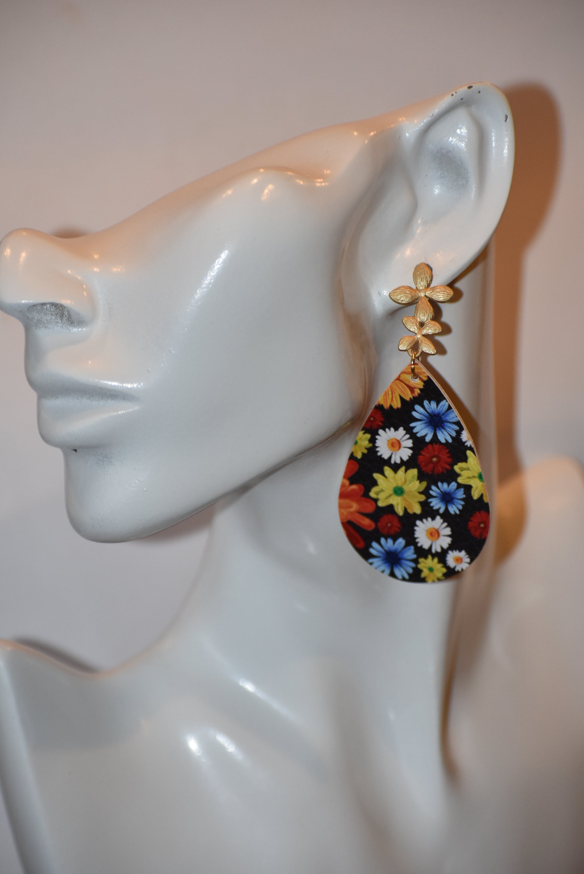 Add a pop of color and quirkiness to any outfit with our Key West Collection earrings! The super fun and bright design features a black background with a vibrant, multi-colored flowered pattern. The unique gold posts add a touch of whimsy, making these earrings truly one-of-a-kind. Get ready to fall in love with these unique flower posts!" 🌺💛