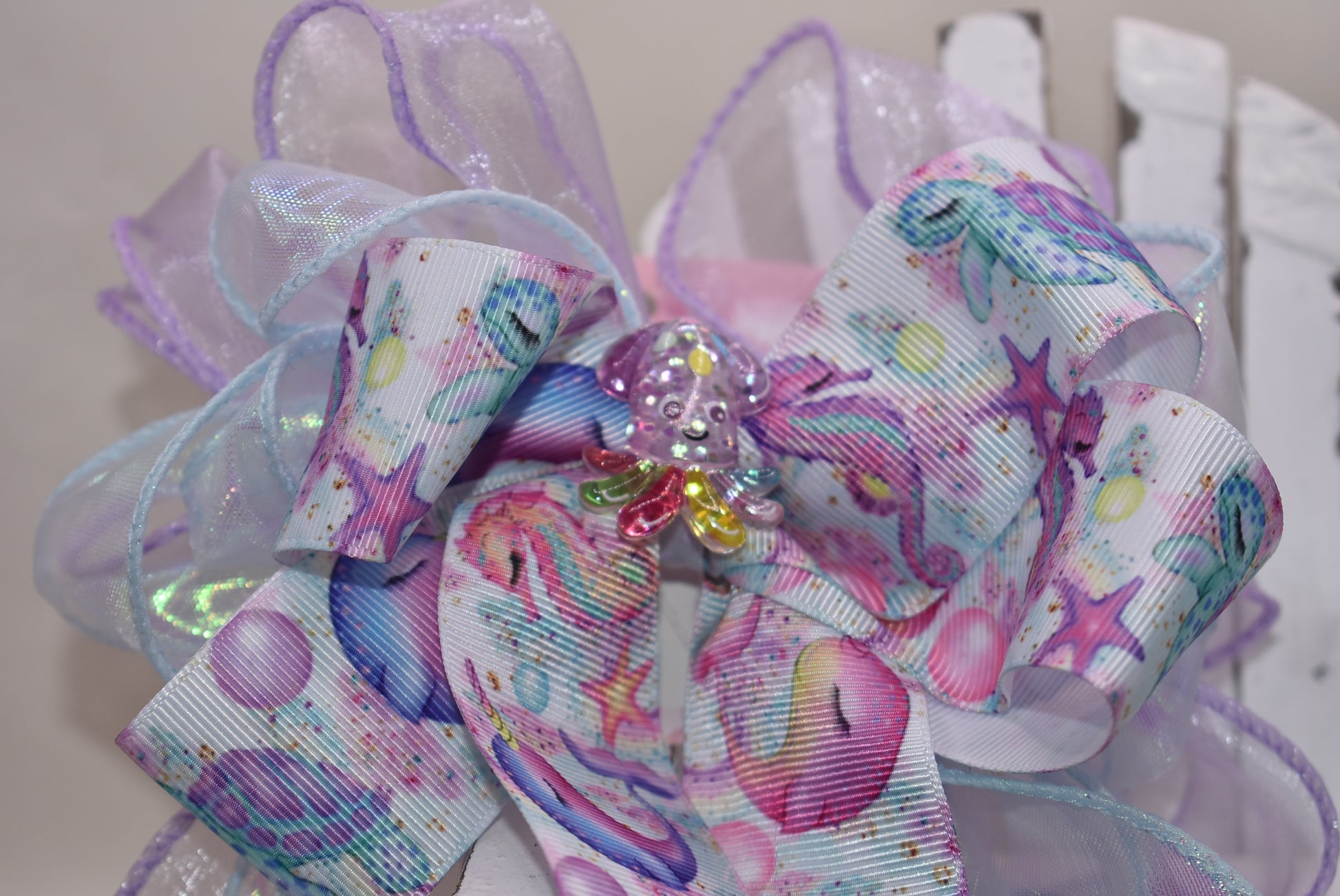 Make a splash with this playful nautical-themed long bow! Layers of beautiful ribbon cascade gracefully, topped with the cutest octopus charm 🐙 for an adorable touch. Featuring a French barrette clip with a snap-on closure, it ensures a perfect fit for any hair adventure. Perfect for adding a sea-inspired charm to your look! ⚓🌊