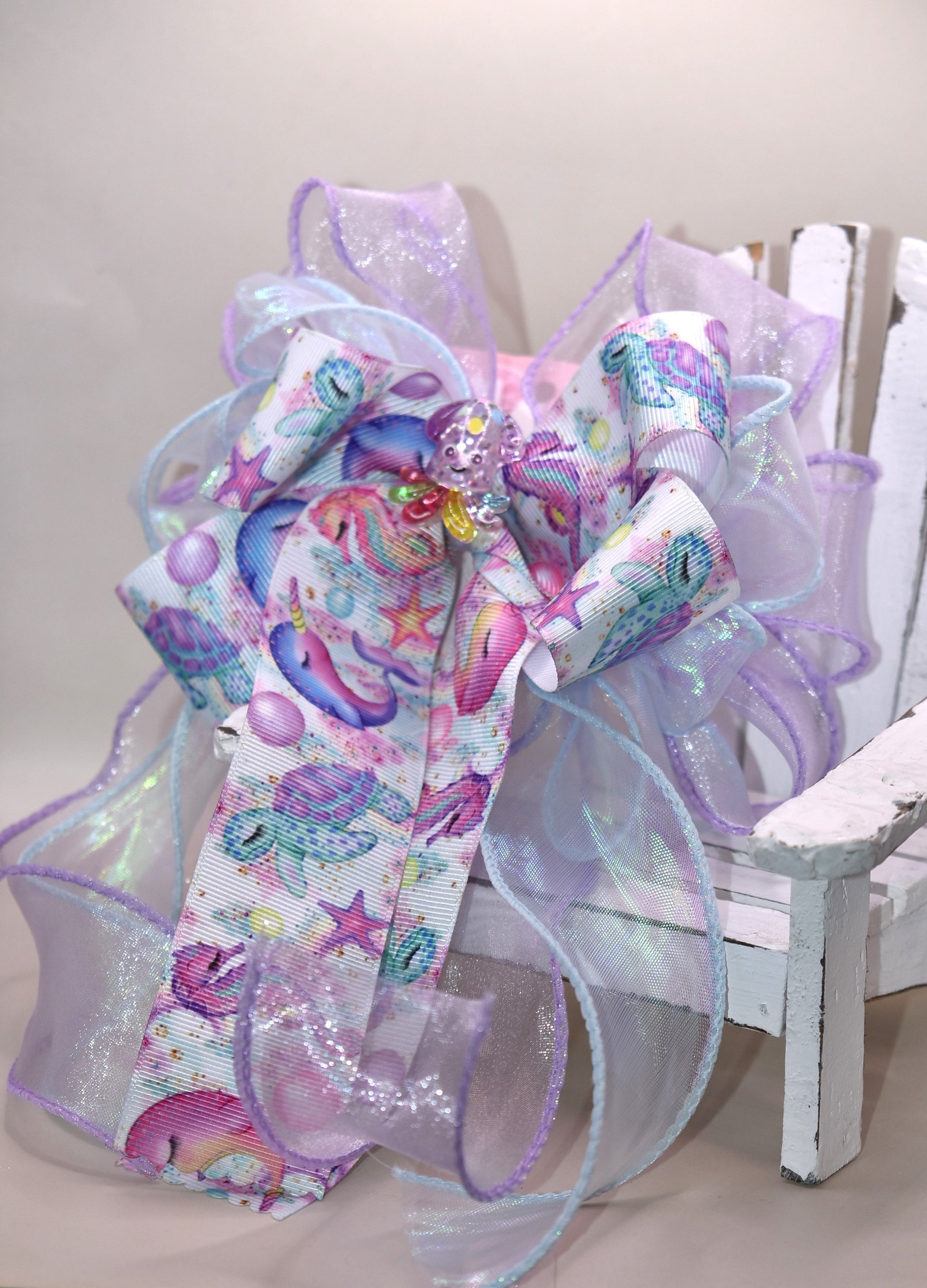 Make a splash with this playful nautical-themed long bow! Layers of beautiful ribbon cascade gracefully, topped with the cutest octopus charm 🐙 for an adorable touch. Featuring a French barrette clip with a snap-on closure, it ensures a perfect fit for any hair adventure. Perfect for adding a sea-inspired charm to your look! ⚓🌊