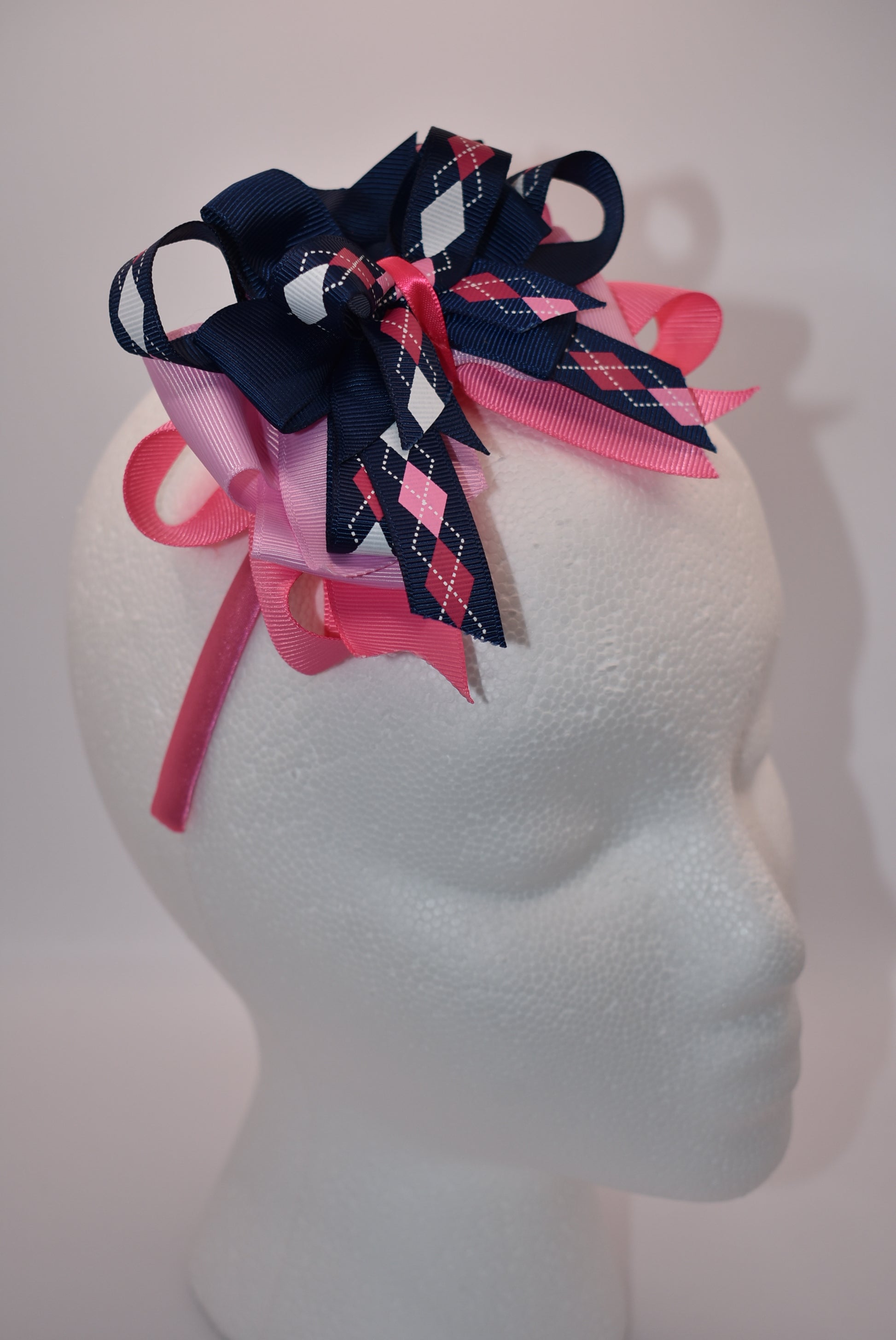 Elevate your style with Nana's Headband Collection! The cool blue, pink and white color combination is perfect for any outfit. The pretty pink satin-wrapped headband adds a touch of elegance, while the layers of quality ribbon give it a unique charm. Say goodbye to boring hair days with this playful and stylish accessory.