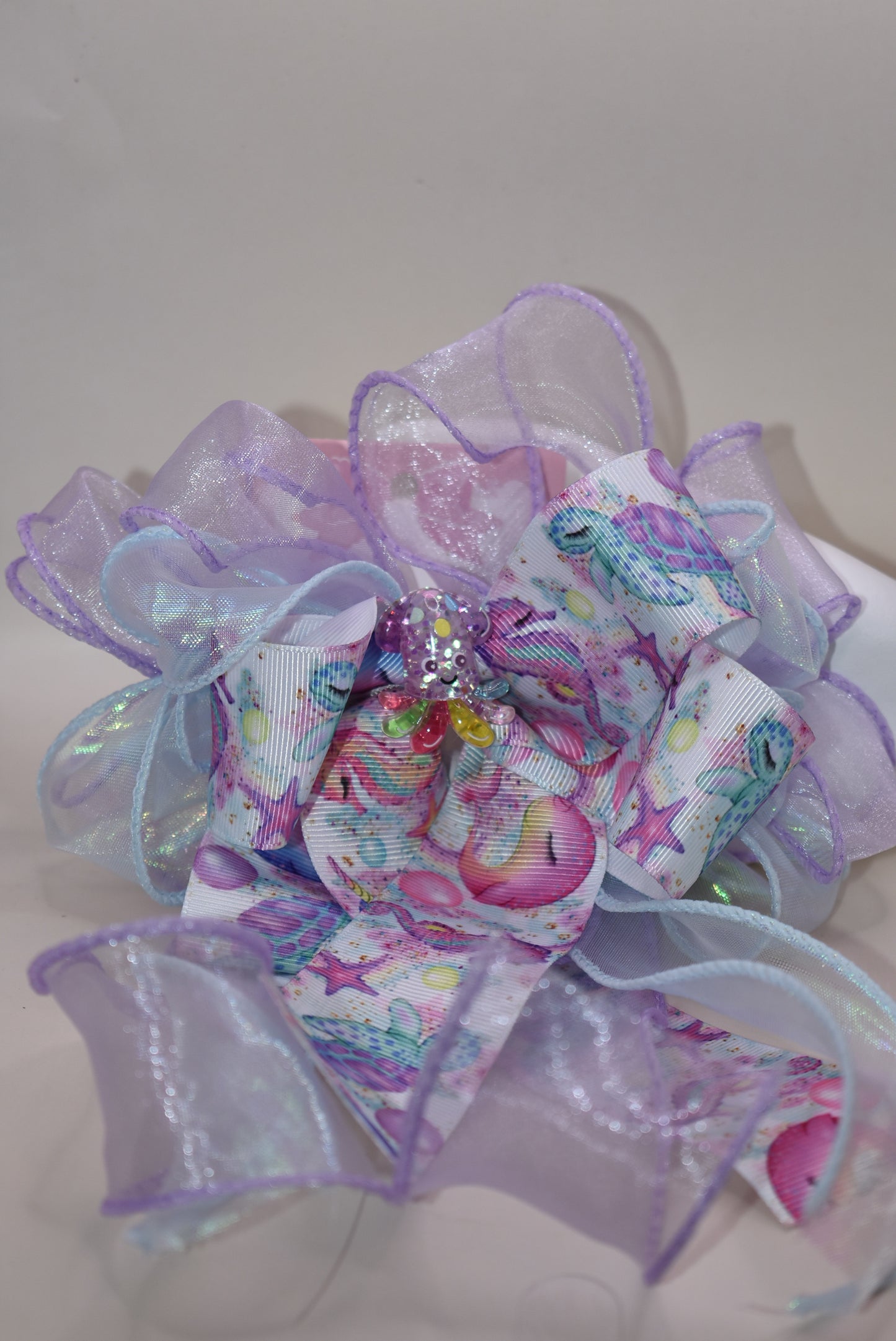 Make a splash with this playful nautical-themed long bow! Layers of beautiful ribbon cascade gracefully, topped with the cutest octopus charm 🐙 for an adorable touch. Featuring a French barrette clip with a snap-on closure, it ensures a perfect fit for any hair adventure. Perfect for adding a sea-inspired charm to your look! ⚓🌊