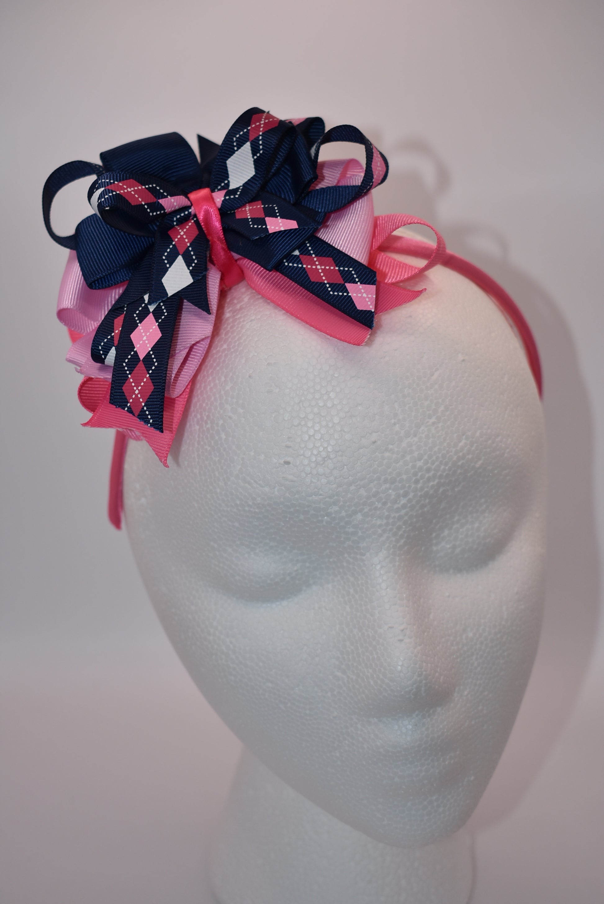 Elevate your style with Nana's Headband Collection! The cool blue, pink and white color combination is perfect for any outfit. The pretty pink satin-wrapped headband adds a touch of elegance, while the layers of quality ribbon give it a unique charm. Say goodbye to boring hair days with this playful and stylish accessory.
