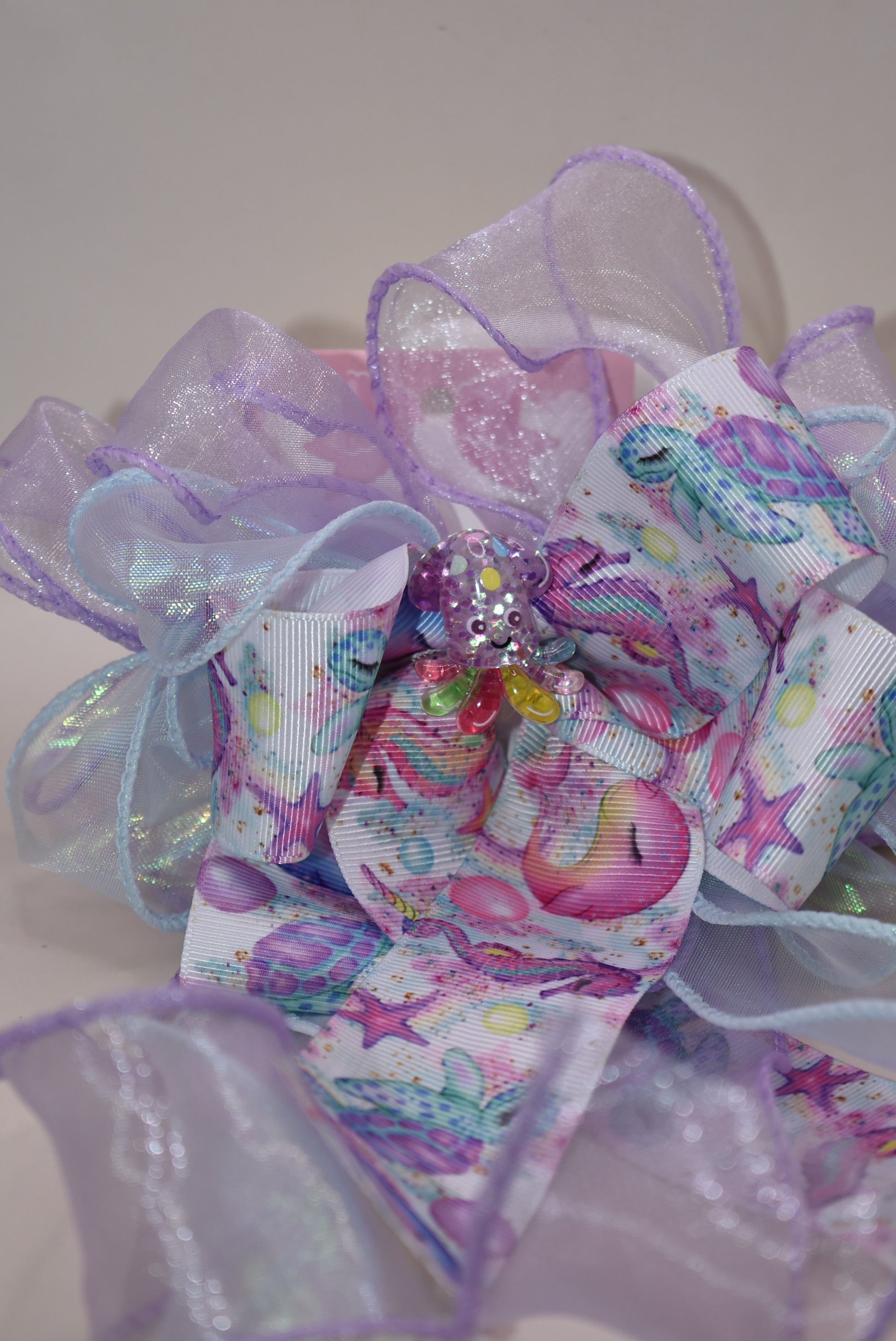 Make a splash with this playful nautical-themed long bow! Layers of beautiful ribbon cascade gracefully, topped with the cutest octopus charm 🐙 for an adorable touch. Featuring a French barrette clip with a snap-on closure, it ensures a perfect fit for any hair adventure. Perfect for adding a sea-inspired charm to your look! ⚓🌊