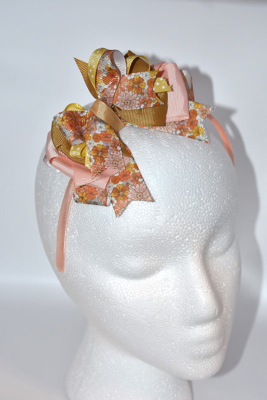 Add a pop of charm with this flower headband 🌸 Layers of delicate ribbons dance atop a slim satin band, bringing playful elegance to any outfit. Perfect all year round, but especially cozy and cute for fall 🍂✨ Embrace your inner flower child with Nana's Headband Collection 7!