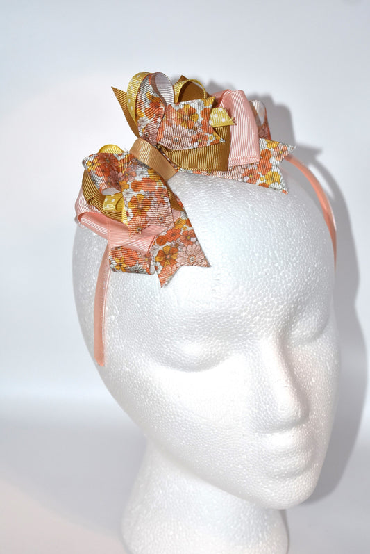 Add a pop of charm with this flower headband 🌸 Layers of delicate ribbons dance atop a slim satin band, bringing playful elegance to any outfit. Perfect all year round, but especially cozy and cute for fall 🍂✨ Embrace your inner flower child with Nana's Headband Collection 7!