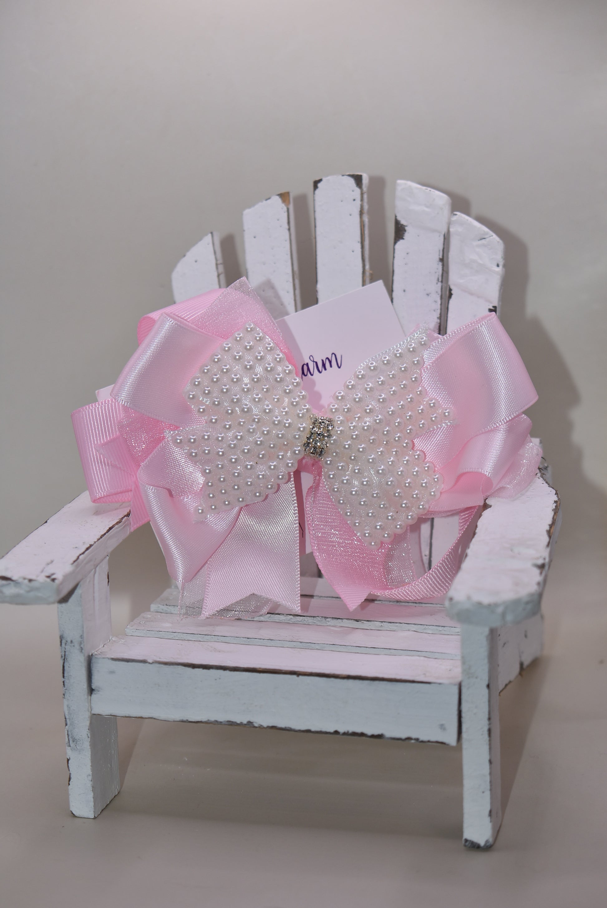 Add a splash of charm with this beautiful pink bow from Nana's Collection! 🌸 Layers of soft pink ribbons create a perfect princess look, topped with a sparkling pearl and crystal wrap ✨. The wrapped alligator clip makes it super easy to wear all day long. Perfect for the little girl who loves everything pink and pretty! 🎀💕