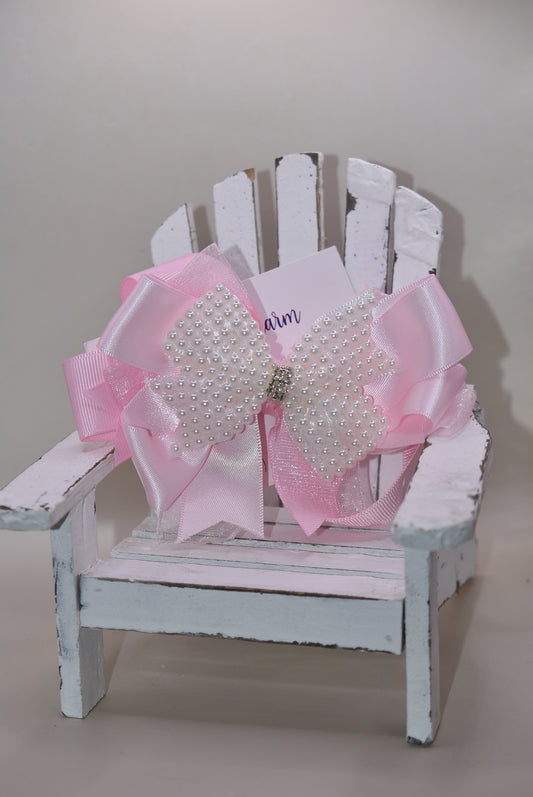 Add a splash of charm with this beautiful pink bow from Nana's Collection! 🌸 Layers of soft pink ribbons create a perfect princess look, topped with a sparkling pearl and crystal wrap ✨. The wrapped alligator clip makes it super easy to wear all day long. Perfect for the little girl who loves everything pink and pretty! 🎀💕