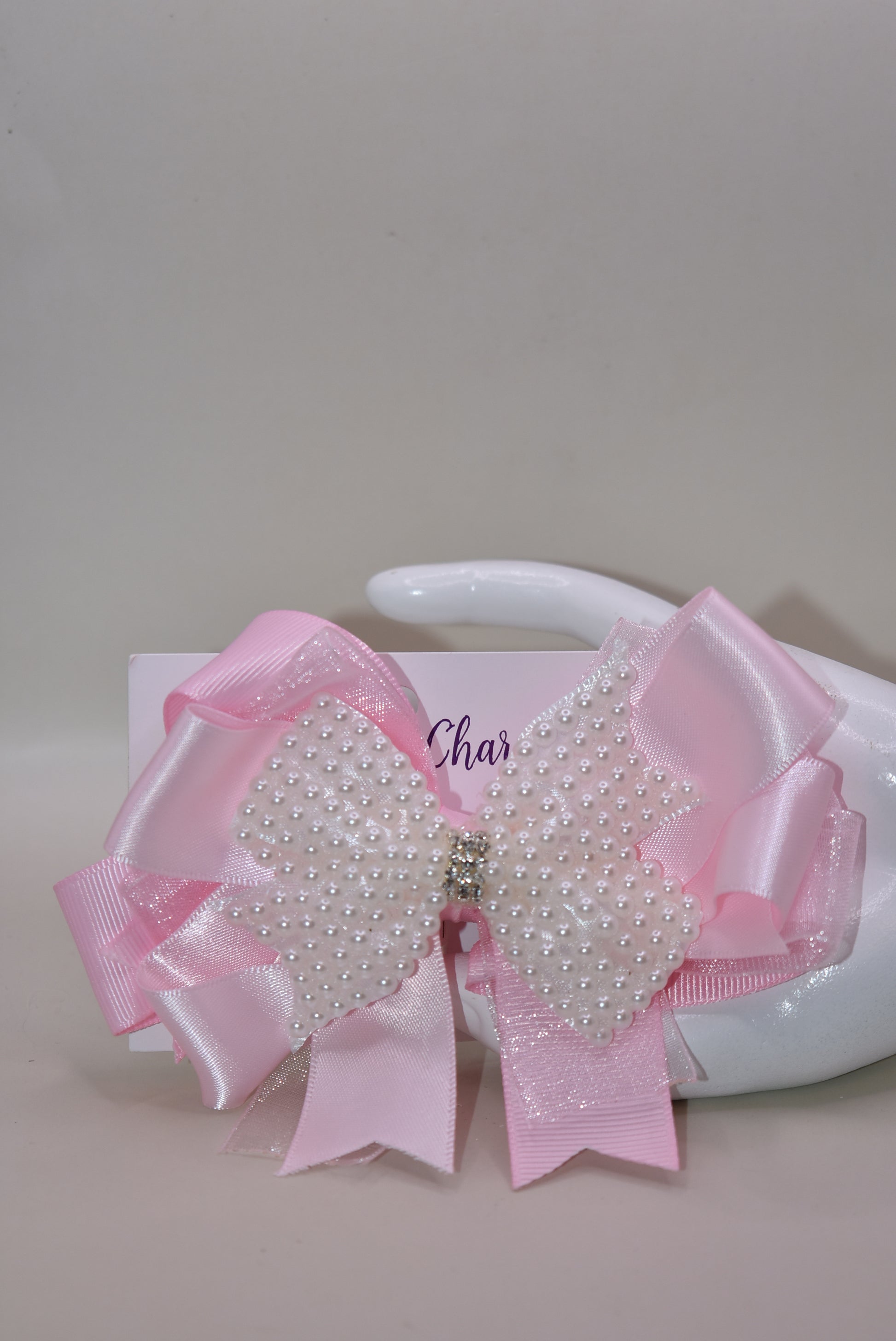 Add a splash of charm with this beautiful pink bow from Nana's Collection! 🌸 Layers of soft pink ribbons create a perfect princess look, topped with a sparkling pearl and crystal wrap ✨. The wrapped alligator clip makes it super easy to wear all day long. Perfect for the little girl who loves everything pink and pretty! 🎀💕