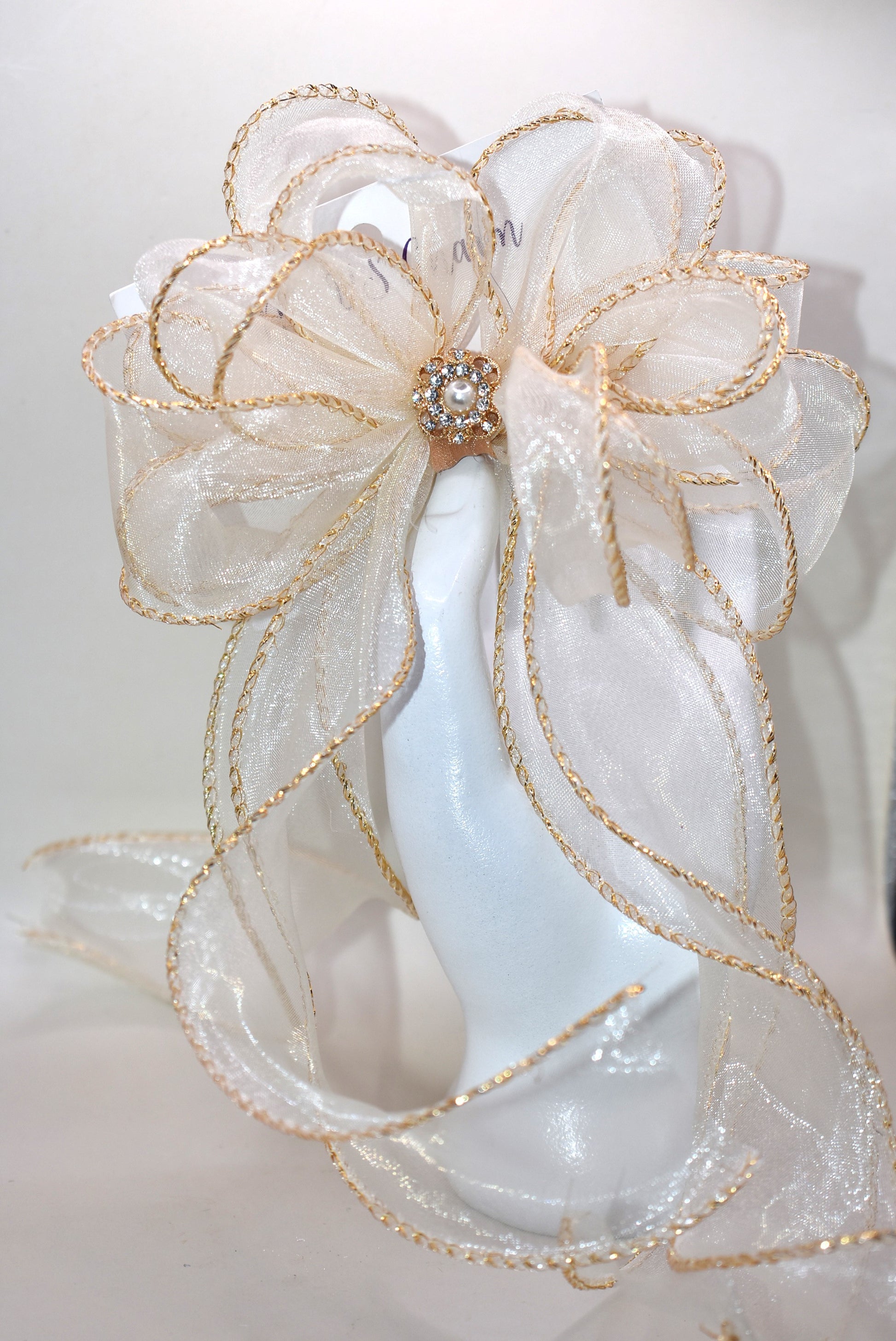 Elevate your ensemble with the Long Tail Collection bow, featuring elegant gold fish tail edging and a stunning gold gem accent. This refined accessory is perfect for any special occasion and suits all ages with its timeless appeal. The alligator-wrapped clip ensures a secure and comfortable fit, adding a subtle touch of sophistication to your look.