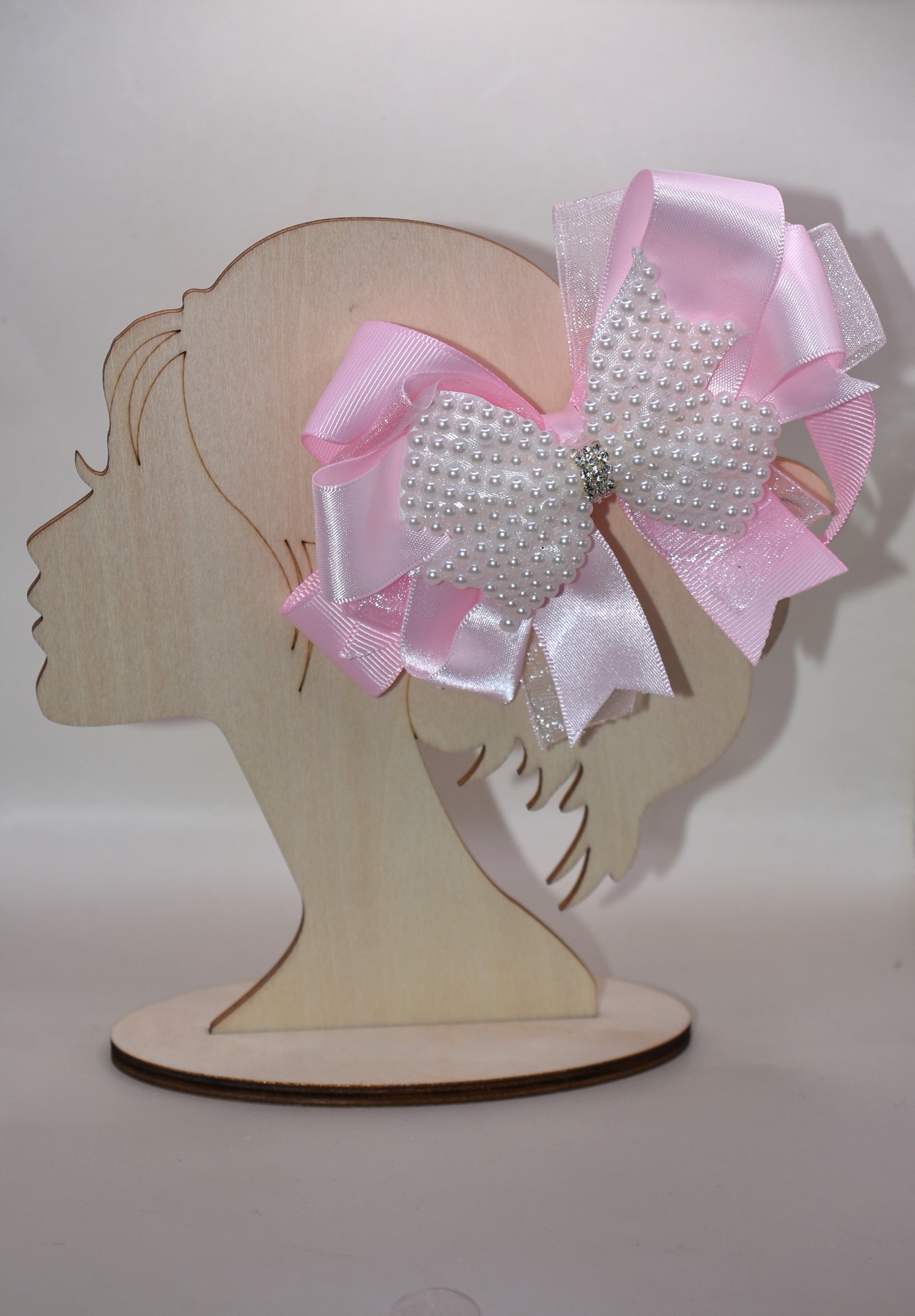 Add a splash of charm with this beautiful pink bow from Nana's Collection! 🌸 Layers of soft pink ribbons create a perfect princess look, topped with a sparkling pearl and crystal wrap ✨. The wrapped alligator clip makes it super easy to wear all day long. Perfect for the little girl who loves everything pink and pretty! 🎀💕