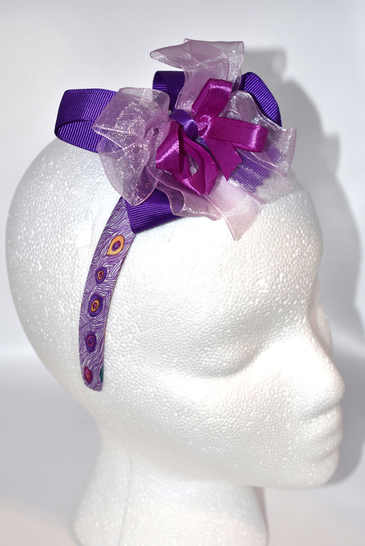 Get ready to turn heads with Nana's Collection Headband 9! 💜 This playful purple headband features layered ribbons that add a fun, stylish pop to any look. Perfect for brightening your day with a splash of color and charm! 🎀✨