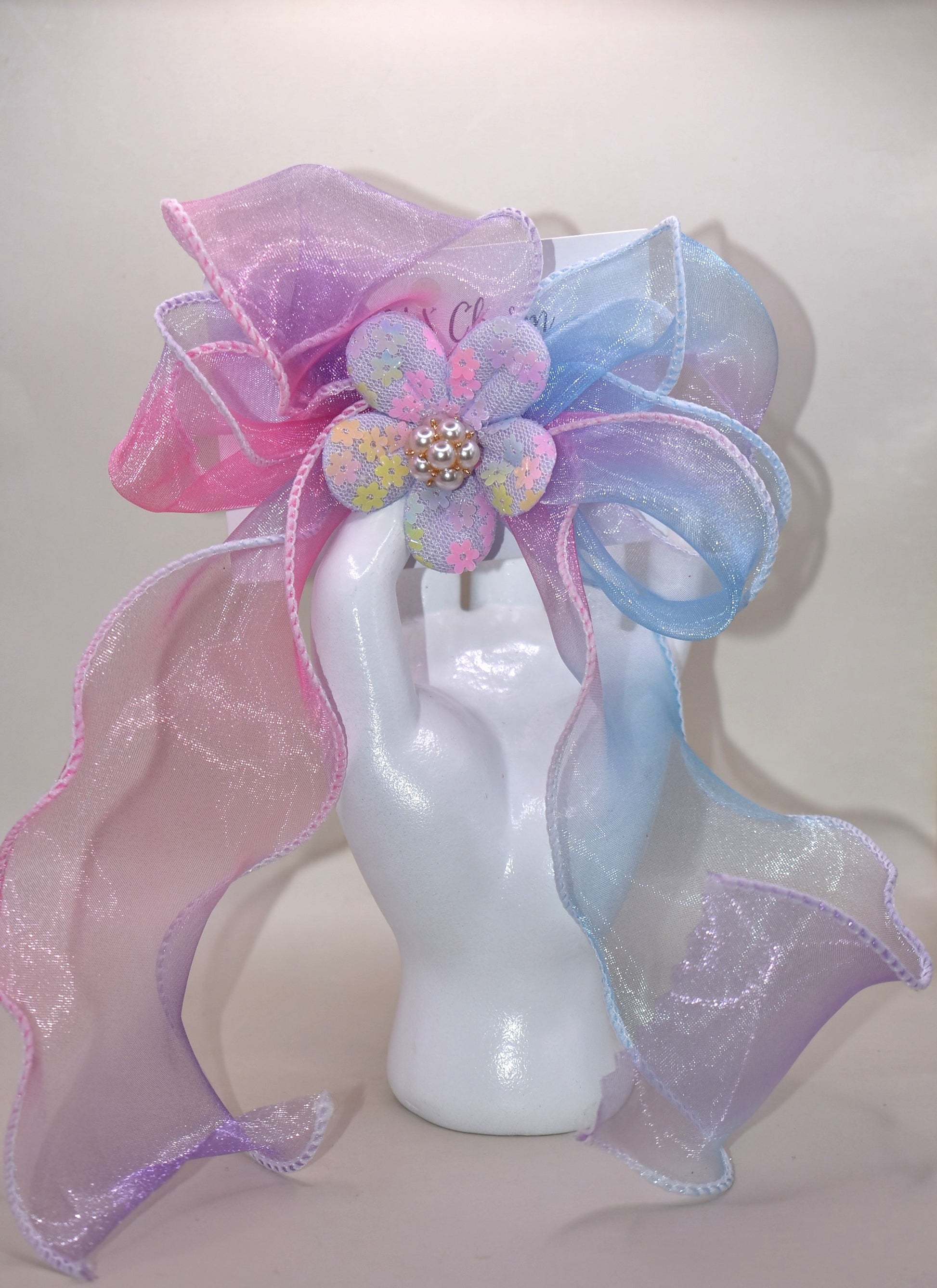 Brighten your style with the Long Tail Collection 2 bow! 🌈 This playful accessory features a colorful sheer ribbon topped with a charming fabric piece and a delicate pearl charm for that perfect touch of sparkle ✨. The wrapped alligator clip on the back ensures a secure fit for all-day wear. Add a pop of fun and elegance to any outfit! 🎀🐚
