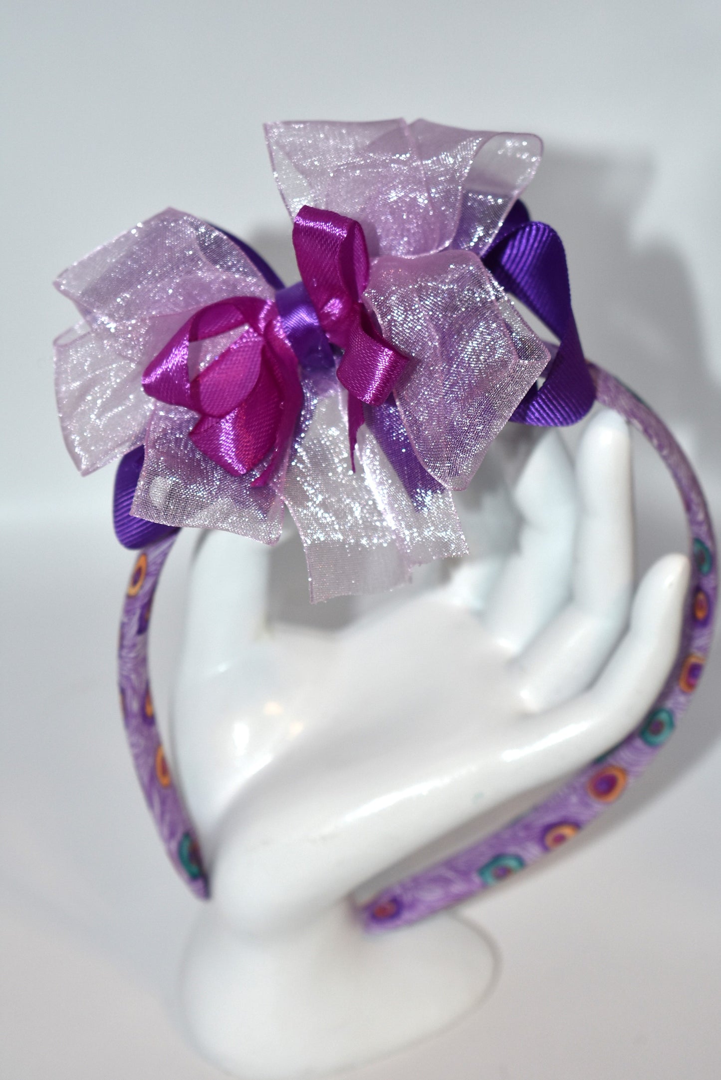 Get ready to turn heads with Nana's Collection Headband 9! 💜 This playful purple headband features layered ribbons that add a fun, stylish pop to any look. Perfect for brightening your day with a splash of color and charm! 🎀✨