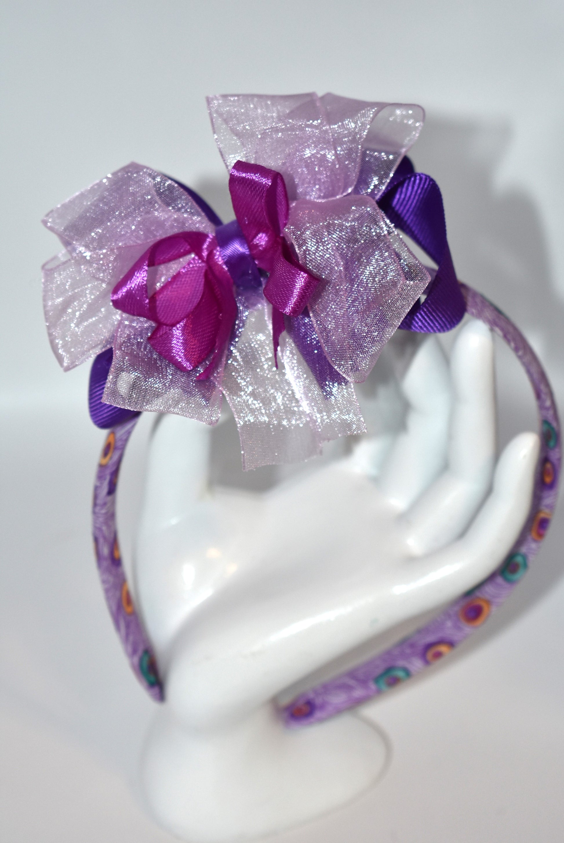 Get ready to turn heads with Nana's Collection Headband 9! 💜 This playful purple headband features layered ribbons that add a fun, stylish pop to any look. Perfect for brightening your day with a splash of color and charm! 🎀✨
