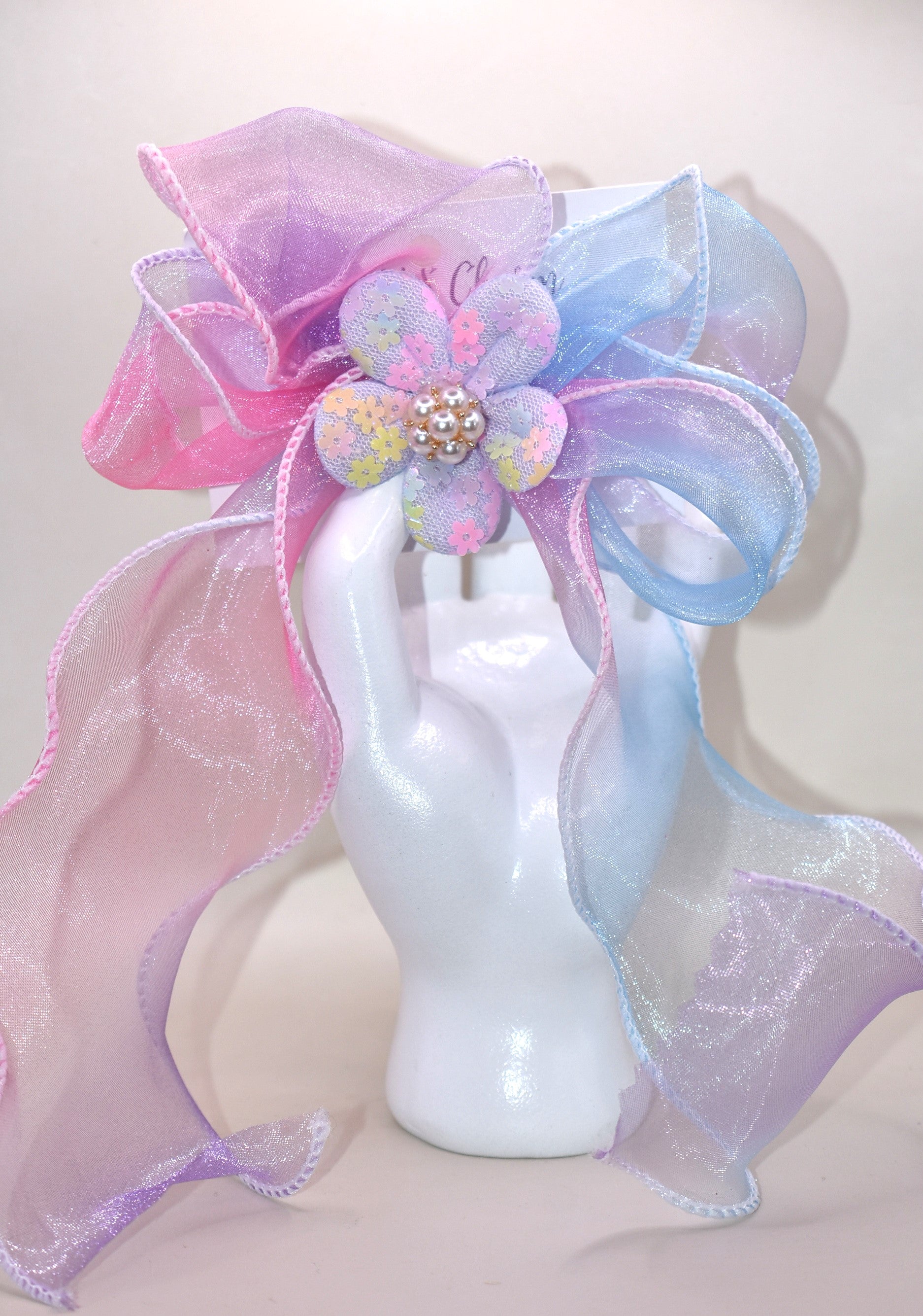 Brighten your style with the Long Tail Collection 2 bow! 🌈 This playful accessory features a colorful sheer ribbon topped with a charming fabric piece and a delicate pearl charm for that perfect touch of sparkle ✨. The wrapped alligator clip on the back ensures a secure fit for all-day wear. Add a pop of fun and elegance to any outfit! 🎀🐚