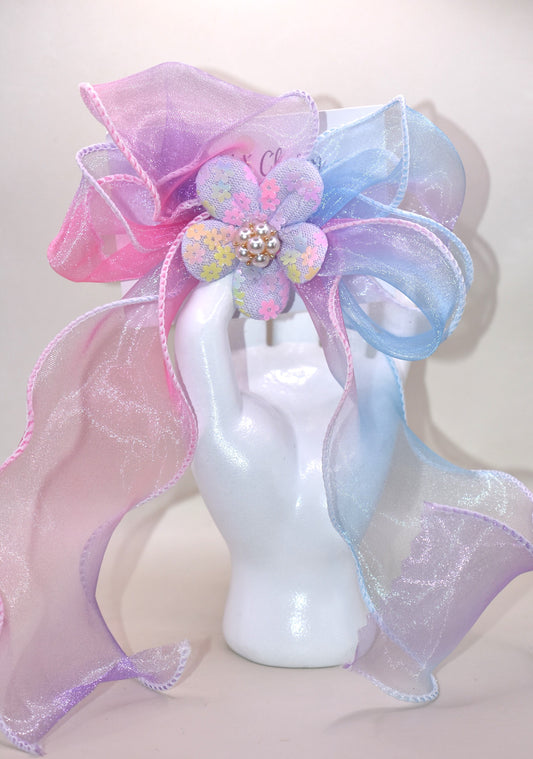 Brighten your style with the Long Tail Collection 2 bow! 🌈 This playful accessory features a colorful sheer ribbon topped with a charming fabric piece and a delicate pearl charm for that perfect touch of sparkle ✨. The wrapped alligator clip on the back ensures a secure fit for all-day wear. Add a pop of fun and elegance to any outfit! 🎀🐚