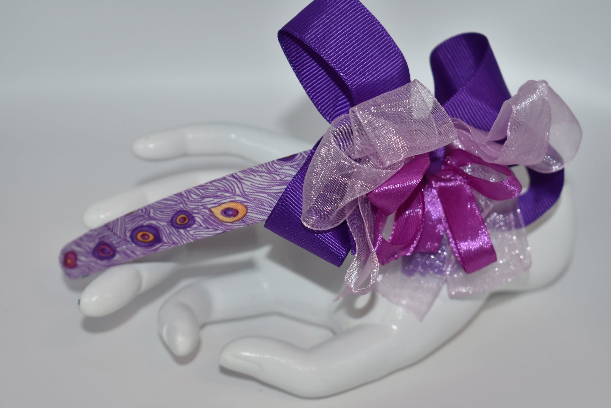 Get ready to turn heads with Nana's Collection Headband 9! 💜 This playful purple headband features layered ribbons that add a fun, stylish pop to any look. Perfect for brightening your day with a splash of color and charm! 🎀✨