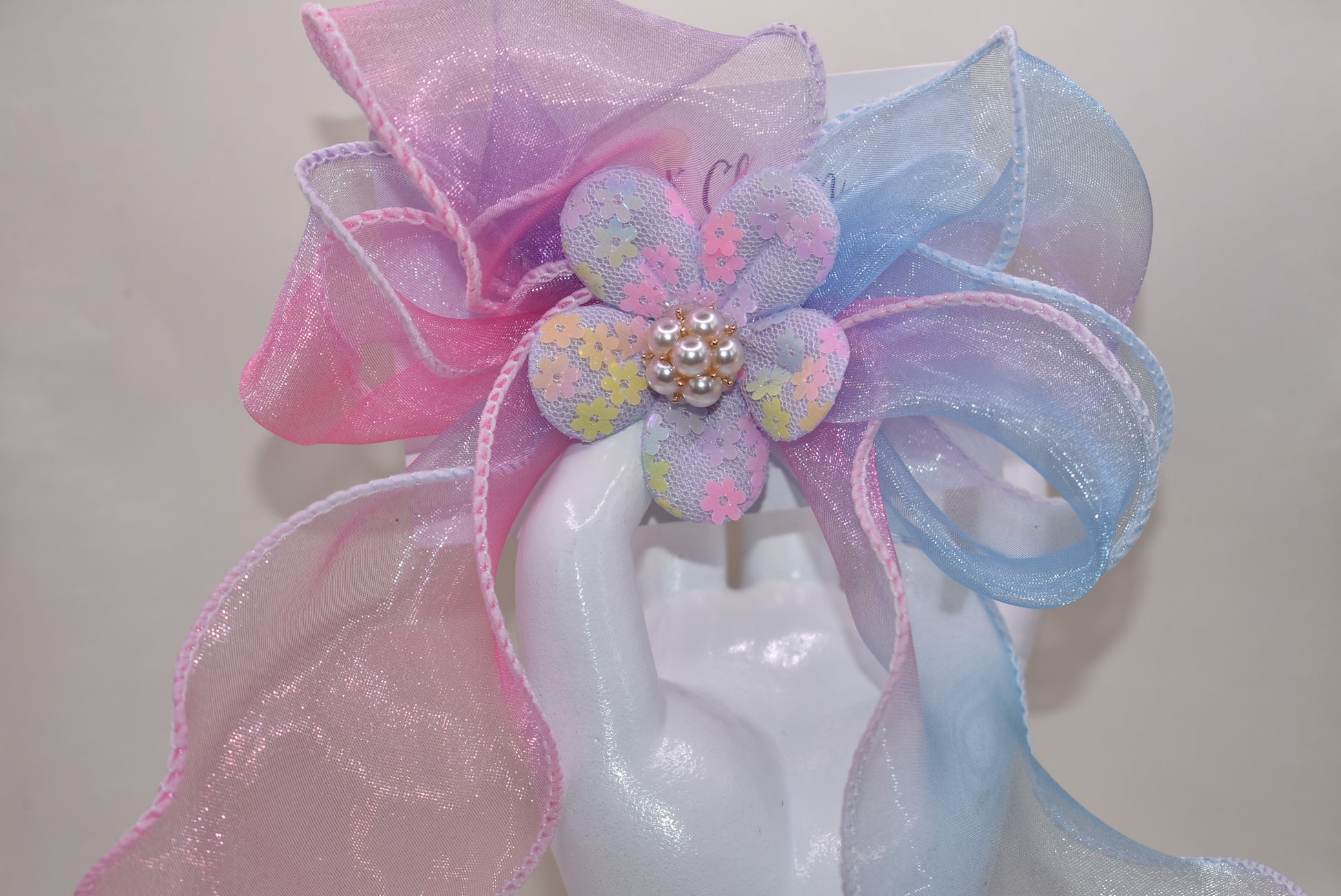 Brighten your style with the Long Tail Collection 2 bow! 🌈 This playful accessory features a colorful sheer ribbon topped with a charming fabric piece and a delicate pearl charm for that perfect touch of sparkle ✨. The wrapped alligator clip on the back ensures a secure fit for all-day wear. Add a pop of fun and elegance to any outfit! 🎀🐚