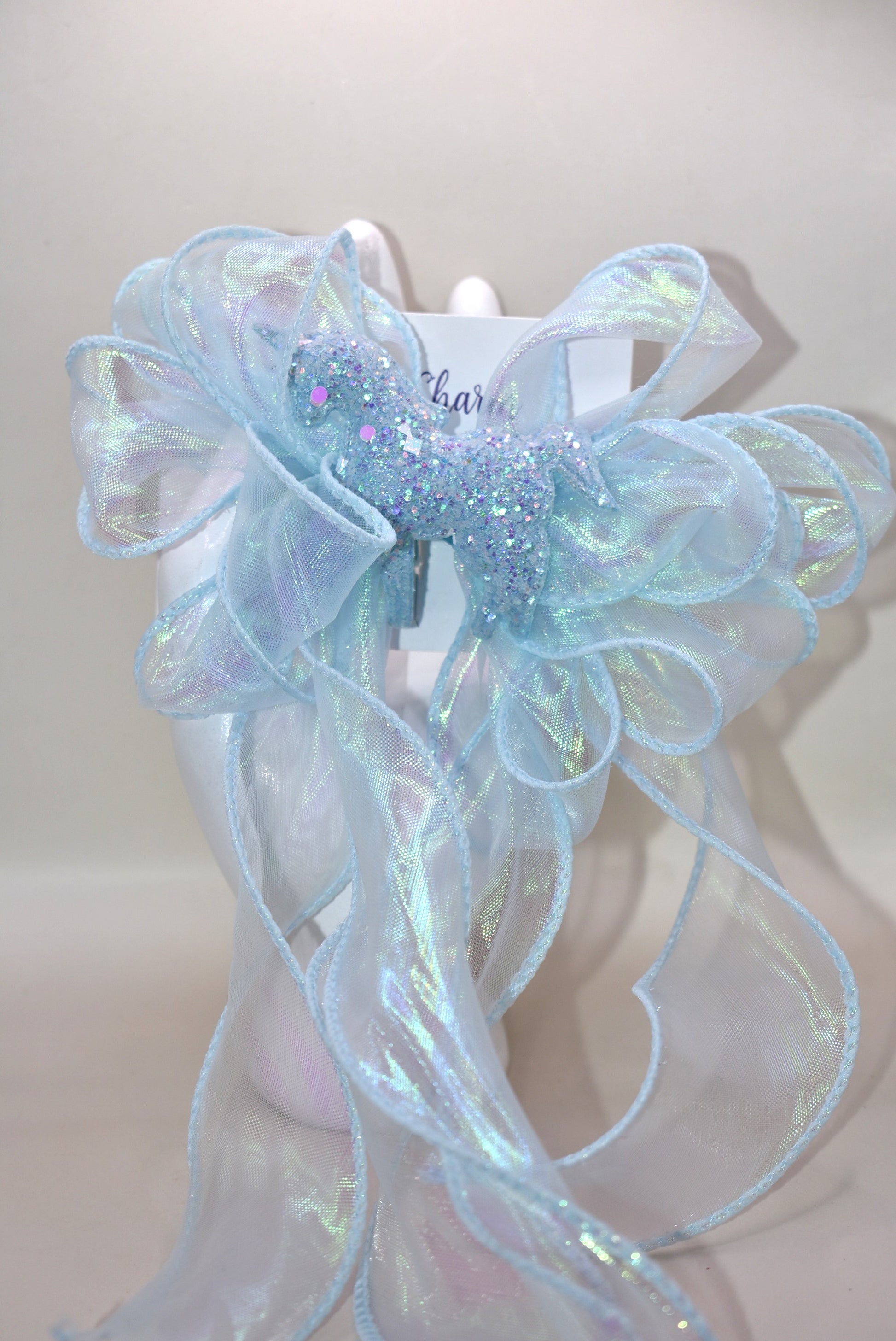 Add a splash of sparkle with this baby blue iridescent fishtail ribbon 🎀, perfectly wrapped on a baby blue alligator clip 🐬. Topping it off is a glittery blue horse 🐴 that brings magic to any outfit! Fun, vibrant, and full of charm—get ready to shine! ✨