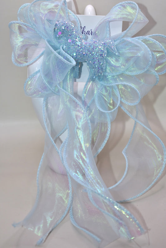 Add a splash of sparkle with this baby blue iridescent fishtail ribbon 🎀, perfectly wrapped on a baby blue alligator clip 🐬. Topping it off is a glittery blue horse 🐴 that brings magic to any outfit! Fun, vibrant, and full of charm—get ready to shine! ✨