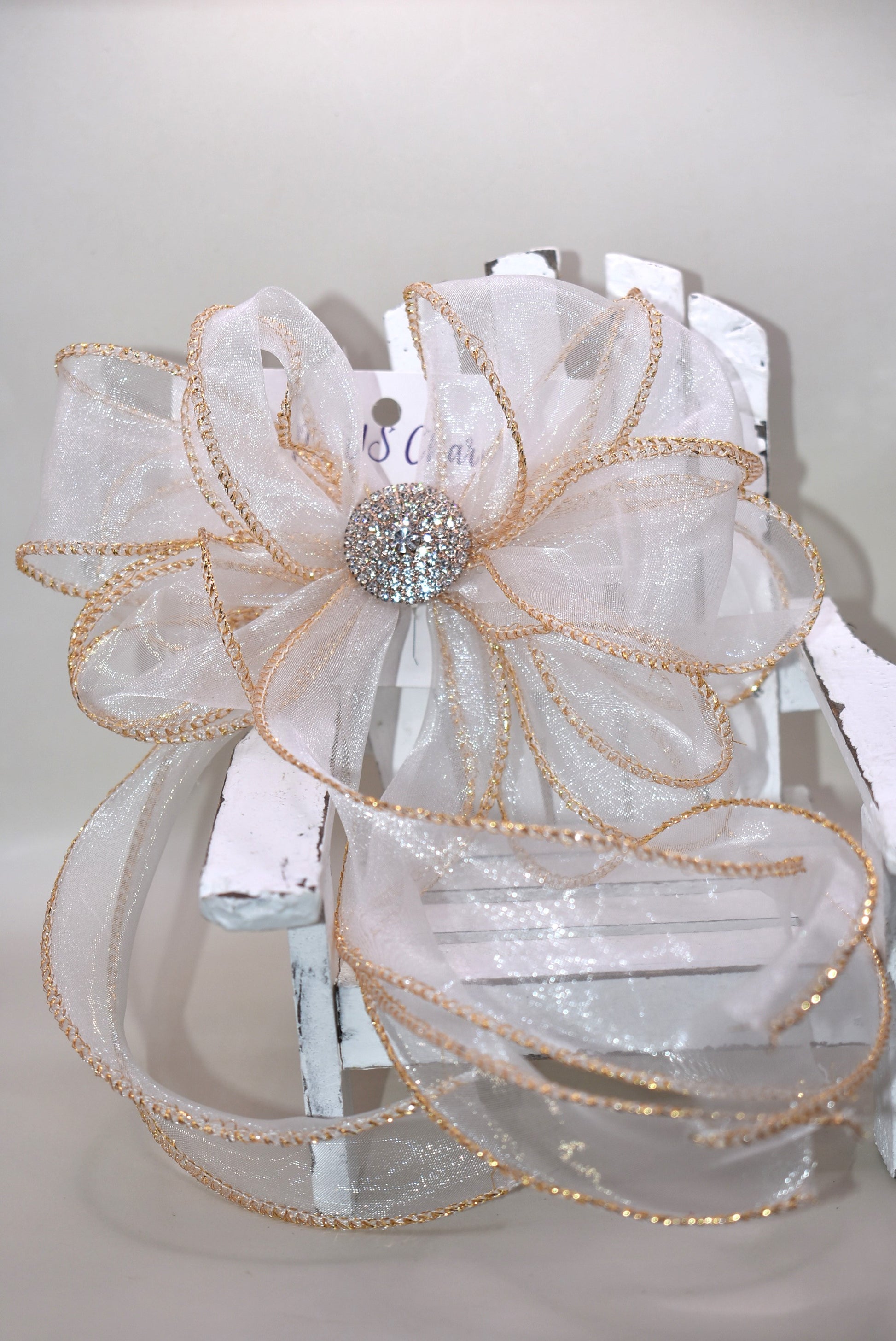 This gorgeous sheer long bow features graceful gold edging and a sparkling gold crystal charm that completes its refined look. Designed for all ages, it combines timeless elegance with practicality, thanks to the wrapped alligator clip for easy wear. A beautiful accessory that will quickly become a beloved favorite.