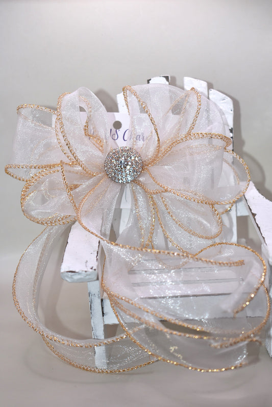 This gorgeous sheer long bow features graceful gold edging and a sparkling gold crystal charm that completes its refined look. Designed for all ages, it combines timeless elegance with practicality, thanks to the wrapped alligator clip for easy wear. A beautiful accessory that will quickly become a beloved favorite.
