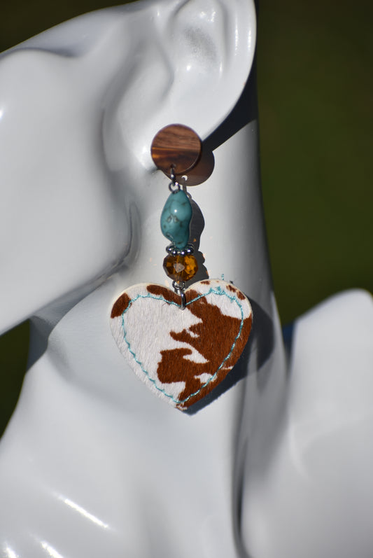 These stylish and lightweight earrings from the Western Collection feature a fun cow print felt heart hanging from a combination of brown crystal and aqua beads set on wood posts for maximum comfort. Show off your western style with these eye-catching earrings.