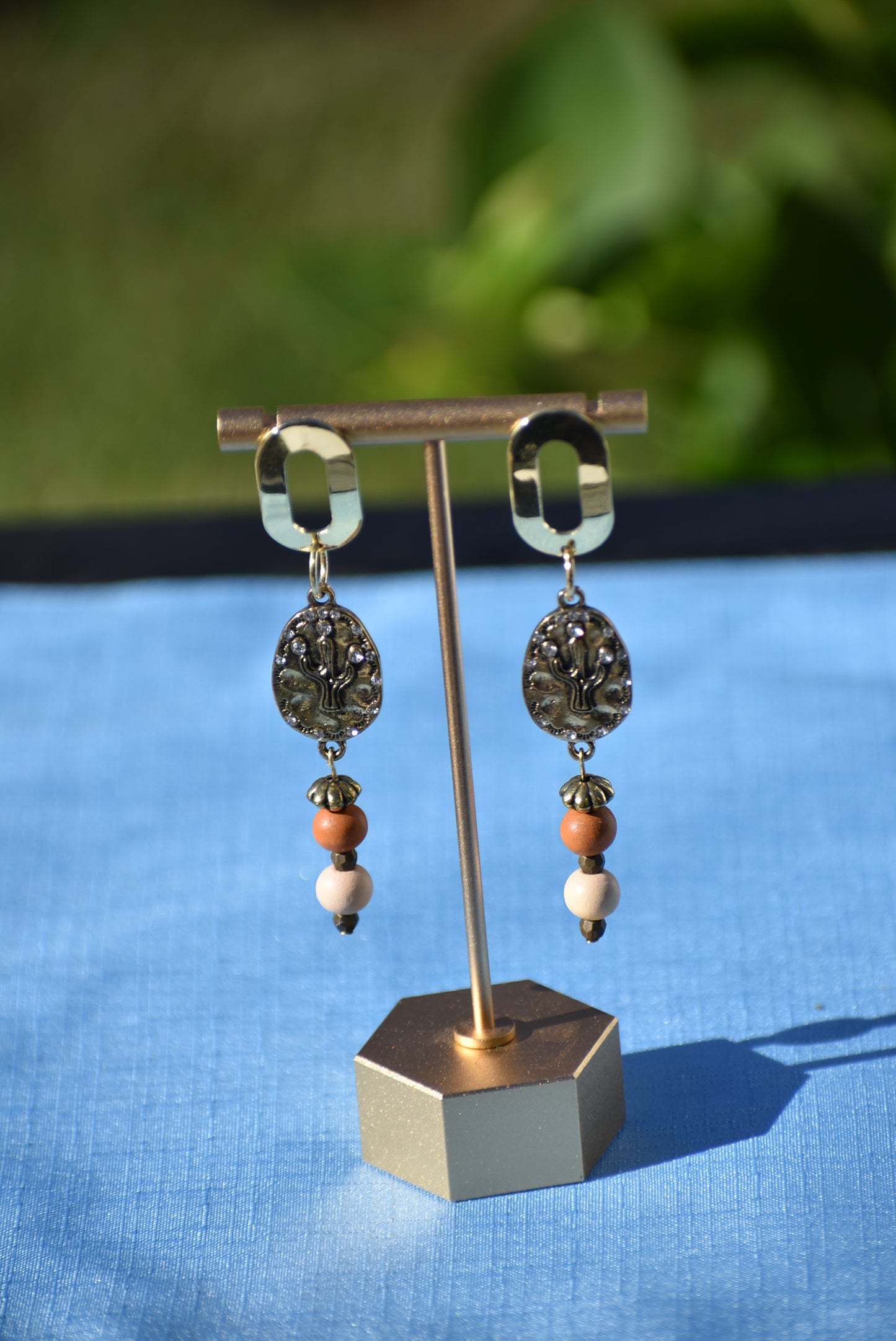 Don these wild West inspired earrings and make a fashion statement worth yodeling about! The open oblong silver posts sweetly support a cactus and crystal charm accompanied by multi-colored wood beads. Comfortable and lightweight, they hang on the long side, but will fill your ears with an unforgettable style. Whoa, Cowboy!