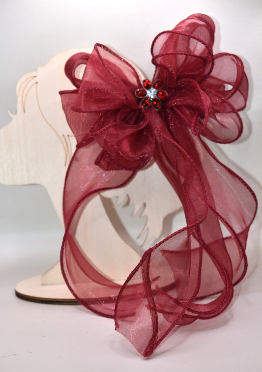 Elevate your ensemble with this elegant long burgundy bow from the Long Tail Collection. Featuring a refined fish tail ribbon design and a sparkling gem centerpiece, it adds a touch of sophistication to any outfit. Securely fastened with a wrapped alligator clip, this accessory combines style and practicality effortlessly.
