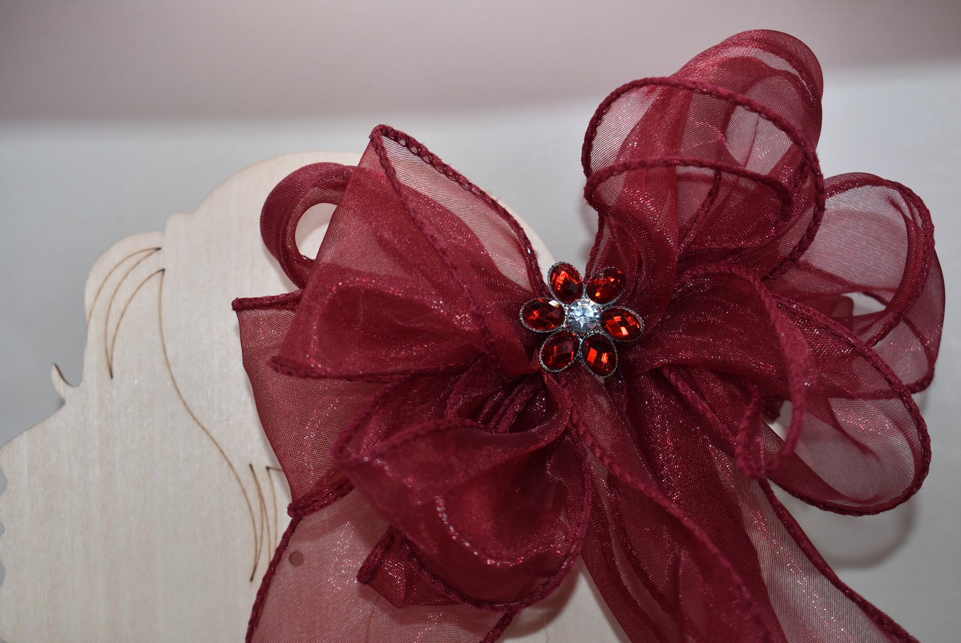 Elevate your ensemble with this elegant long burgundy bow from the Long Tail Collection. Featuring a refined fish tail ribbon design and a sparkling gem centerpiece, it adds a touch of sophistication to any outfit. Securely fastened with a wrapped alligator clip, this accessory combines style and practicality effortlessly.