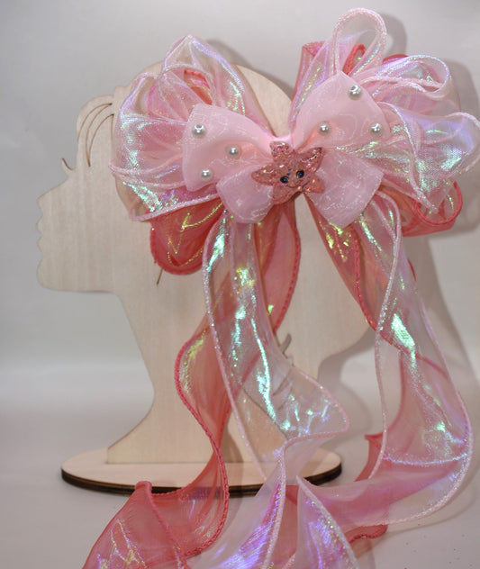 Dive into charm with this ocean-inspired long tail bow! 🌊 Layers of iridescent and sheer ribbons create a magical shimmer, topped with a delicate pearl chiffon bow 🎀. A sparkly starfish charm ✨ adds the perfect touch of seaside sparkle. Easy to wear with a wrapped alligator clip on the back. Fall head over fins for this beauty! 🐚💙