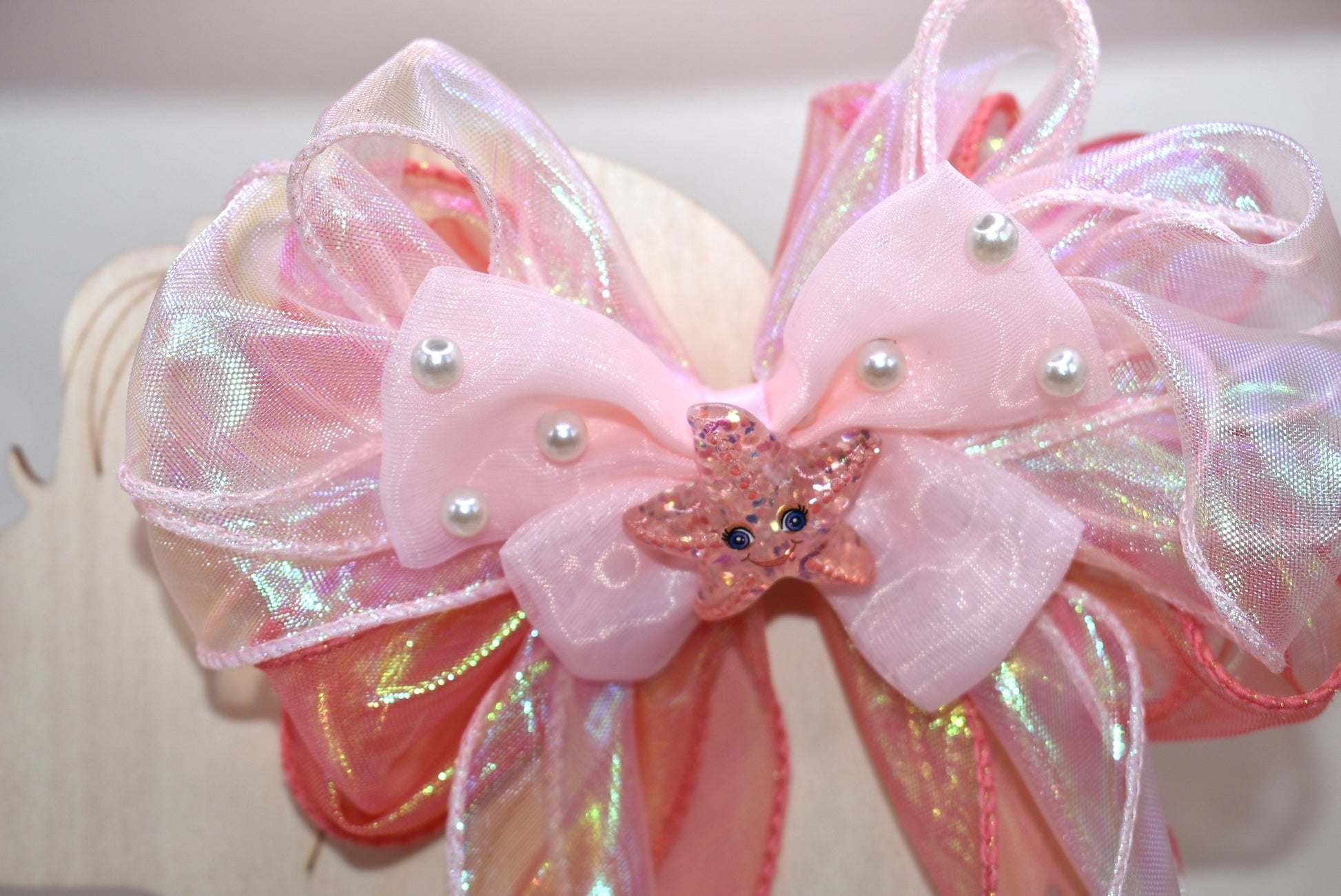 Dive into charm with this ocean-inspired long tail bow! 🌊 Layers of iridescent and sheer ribbons create a magical shimmer, topped with a delicate pearl chiffon bow 🎀. A sparkly starfish charm ✨ adds the perfect touch of seaside sparkle. Easy to wear with a wrapped alligator clip on the back. Fall head over fins for this beauty! 🐚💙