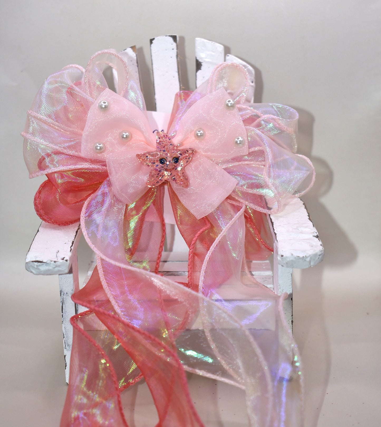Dive into charm with this ocean-inspired long tail bow! 🌊 Layers of iridescent and sheer ribbons create a magical shimmer, topped with a delicate pearl chiffon bow 🎀. A sparkly starfish charm ✨ adds the perfect touch of seaside sparkle. Easy to wear with a wrapped alligator clip on the back. Fall head over fins for this beauty! 🐚💙