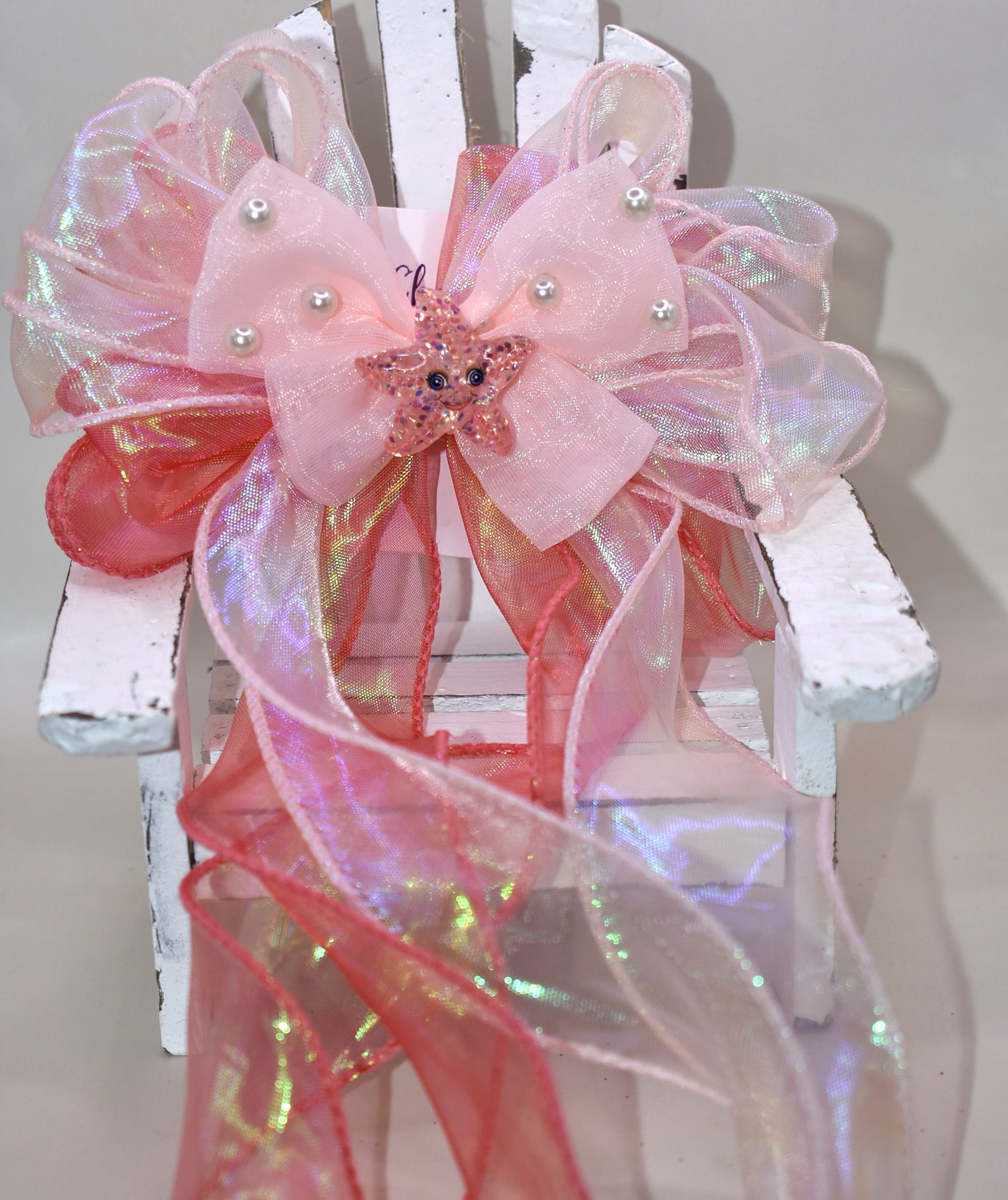 Dive into charm with this ocean-inspired long tail bow! 🌊 Layers of iridescent and sheer ribbons create a magical shimmer, topped with a delicate pearl chiffon bow 🎀. A sparkly starfish charm ✨ adds the perfect touch of seaside sparkle. Easy to wear with a wrapped alligator clip on the back. Fall head over fins for this beauty! 🐚💙