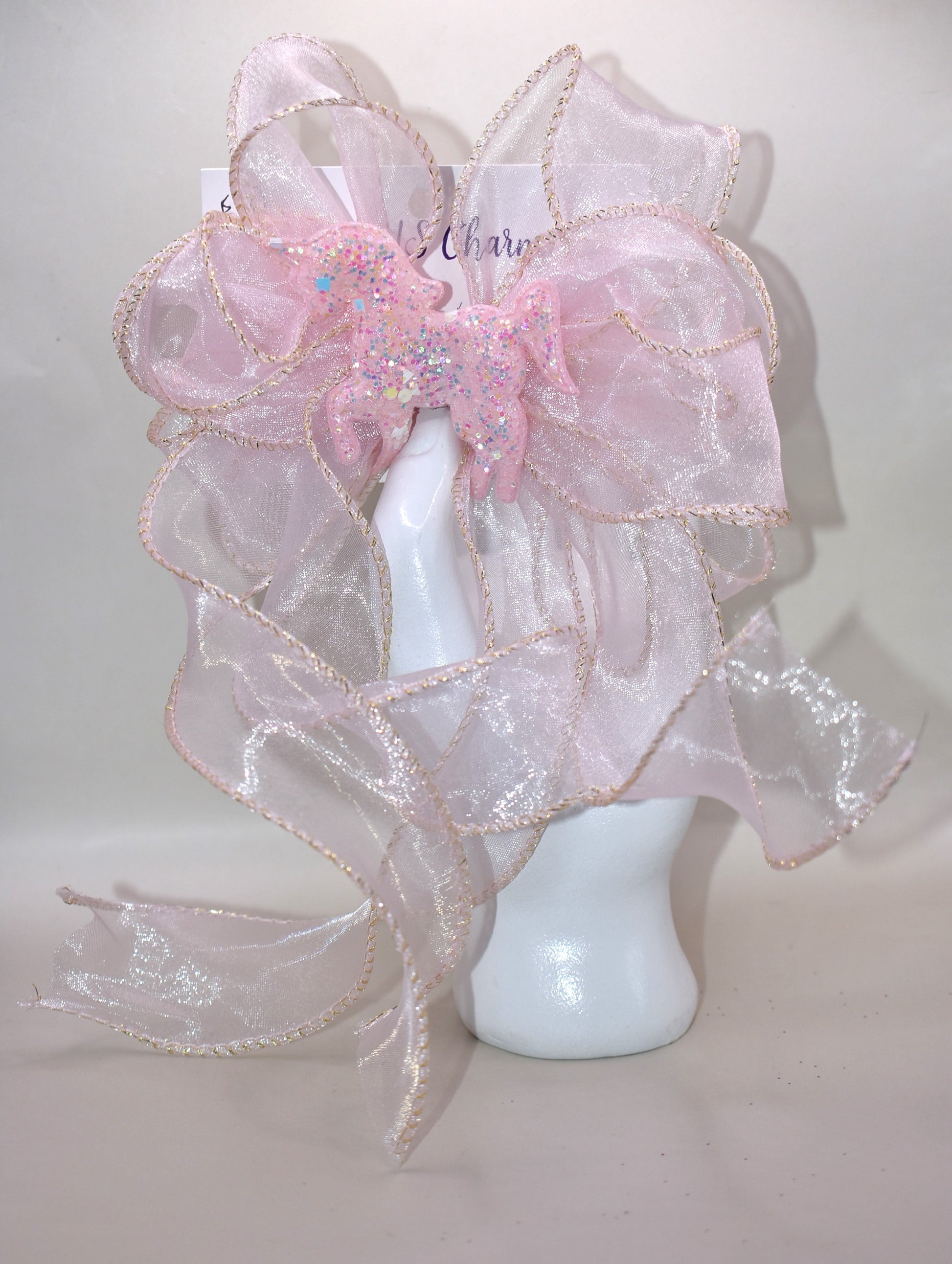 Add a pop of fun with this long pink sheer ribbon bow, topped with a sparkly pink horse that shines bright! Perfectly playful and secured with a wrapped alligator clip, it’s the ultimate pretty-in-pink accessory for any day. 🐴💖✨