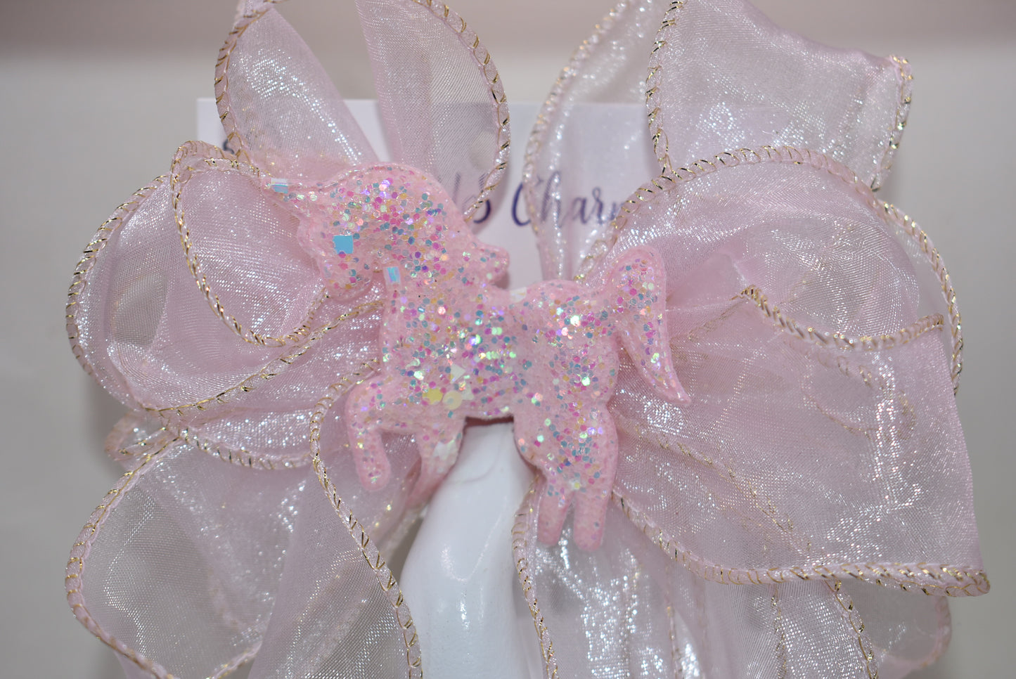 Add a pop of fun with this long pink sheer ribbon bow, topped with a sparkly pink horse that shines bright! Perfectly playful and secured with a wrapped alligator clip, it’s the ultimate pretty-in-pink accessory for any day. 🐴💖✨