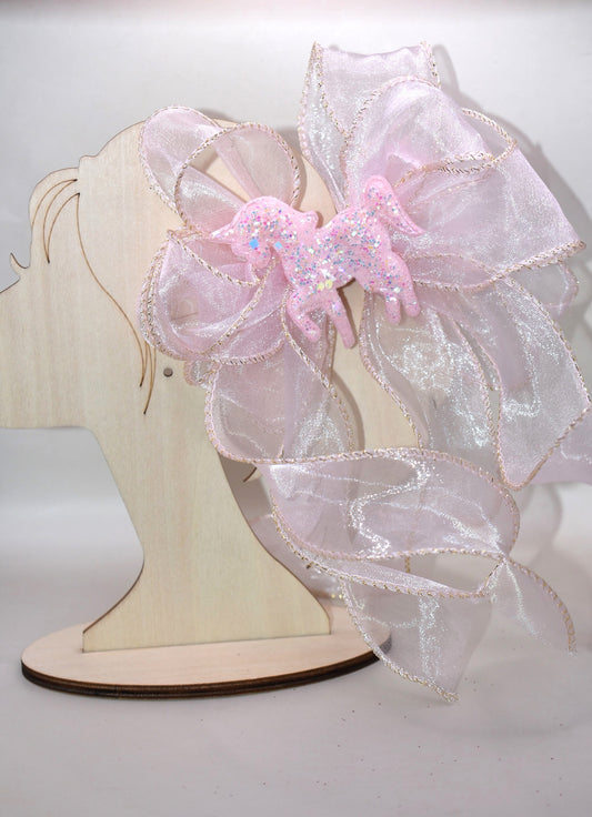 Add a pop of fun with this long pink sheer ribbon bow, topped with a sparkly pink horse that shines bright! Perfectly playful and secured with a wrapped alligator clip, it’s the ultimate pretty-in-pink accessory for any day. 🐴💖✨