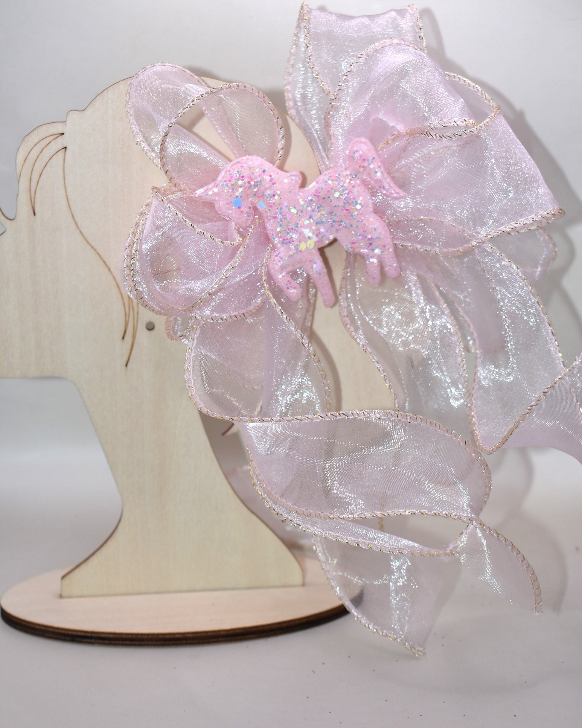 Add a pop of fun with this long pink sheer ribbon bow, topped with a sparkly pink horse that shines bright! Perfectly playful and secured with a wrapped alligator clip, it’s the ultimate pretty-in-pink accessory for any day. 🐴💖✨