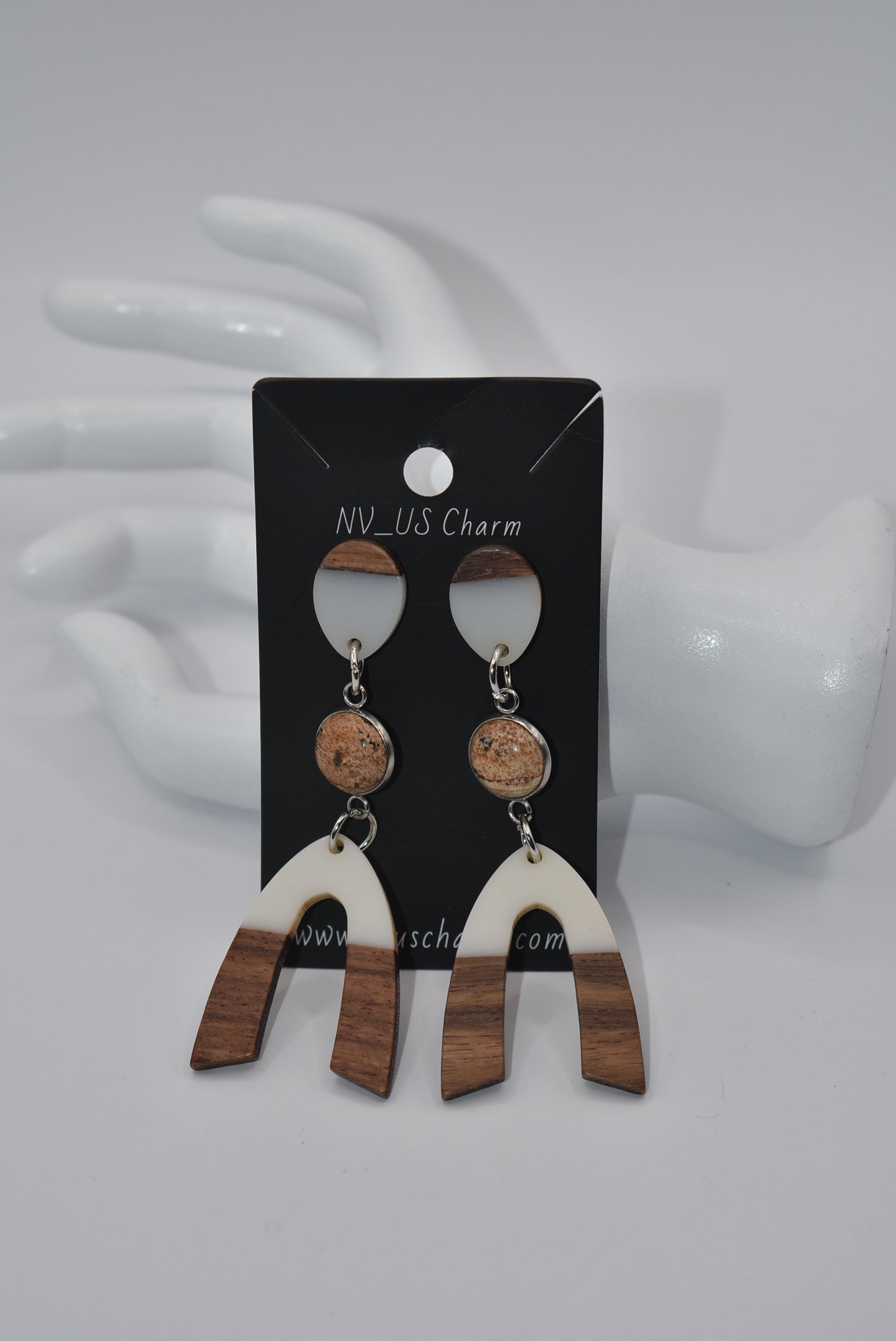 Introducing our Brown Collection earrings! Hypoallergenic, these one-of-a-kind earrings feature a natural and cream color scheme with a stunning cabochon stone in the center. Adorned with a u-shaped wood and resin charm, these earrings hang about 3 inches off the ear. A perfect finishing touch for any outfit!