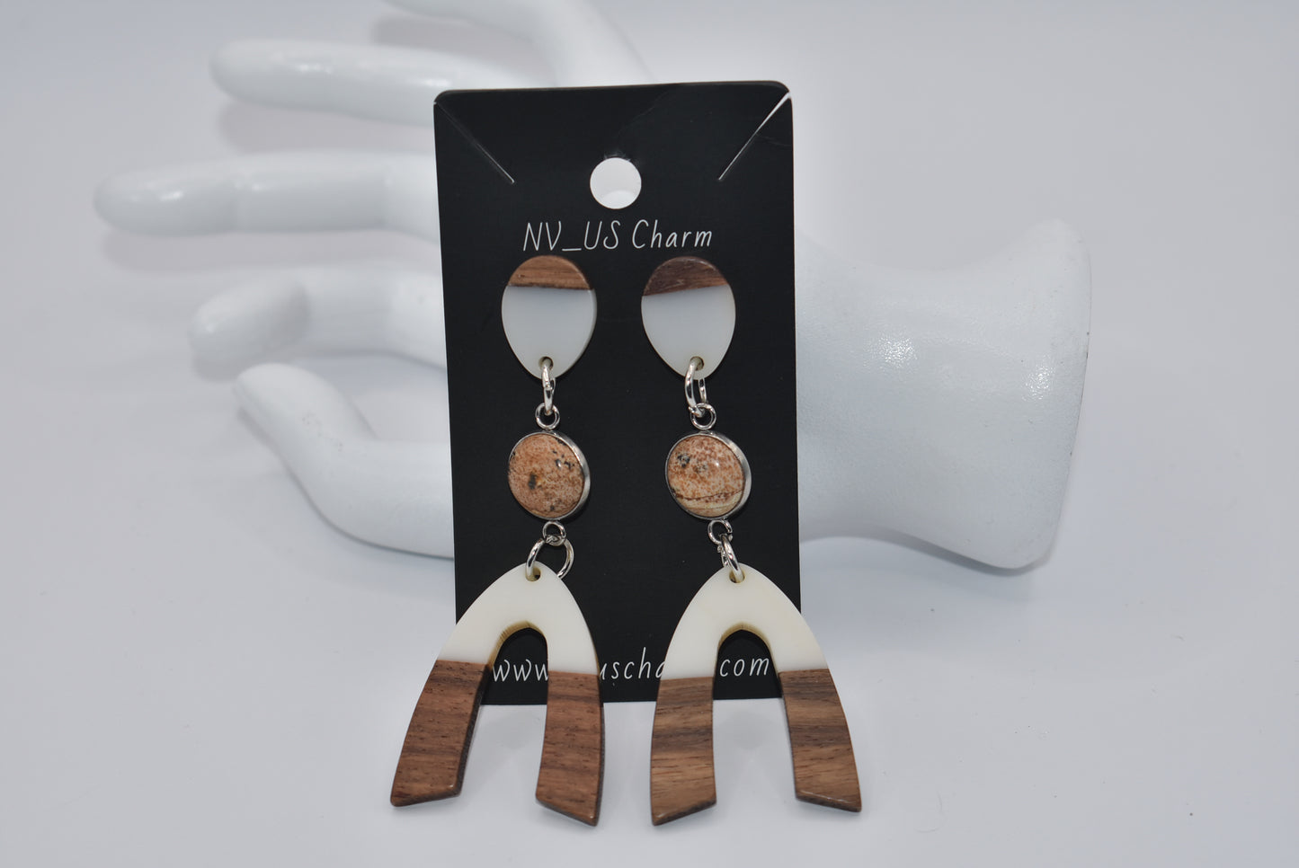 Introducing our Brown Collection earrings! Hypoallergenic, these one-of-a-kind earrings feature a natural and cream color scheme with a stunning cabochon stone in the center. Adorned with a u-shaped wood and resin charm, these earrings hang about 3 inches off the ear. A perfect finishing touch for any outfit!