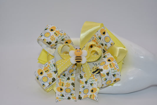 Get ready for summer with Nana's Collection 47! This adorable bumble bow is made of high-quality ribbon and features a cute bumble bee charm on top. Plus, the wrapped alligator clip ensures comfort all day long. Buzz on over and add this to your collection today!