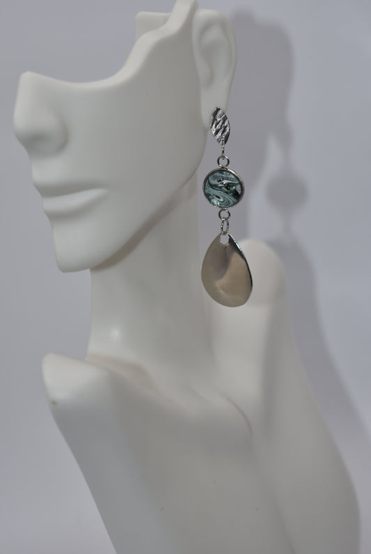 Add a pop of color to your outfit with our Green Collection earrings. This one-of-a-kind piece feature silver teardrop spinners that hang from steel hypoallergenic posts. The pretty green cabochon glass sits in the center, providing a unique touch. These earrings hang about 2 1/2 inches from the ear, making them the perfect accessory to fall in love with!