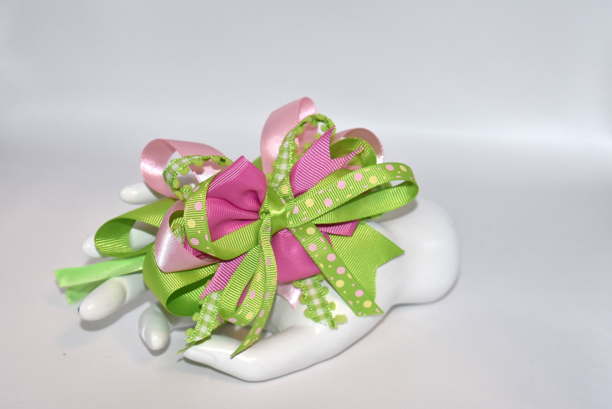 Wrap your hair in pure charm with this one-of-a-kind headband! ✨ Featuring delicate layers of pretty ribbon in a gorgeous green and pink color mix, this skinny satin headband is designed for all-day comfort and style. 🎀 Whether you're heading to work, running errands, or enjoying a casual day out, this beauty keeps your look polished without the fuss. 💚💗 Perfect for anyone who loves a pop of color and a touch of whimsy!
