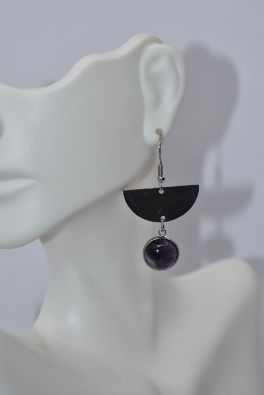 Add a pop of color to your accessories with our Purple Collection earrings! These stainless steel, hypoallergenic hooks hold a beautiful cabochon amethyst stone, making them perfect for sensitive ears. With a unique half-moon design, these earrings are a playful twist on a classic style.