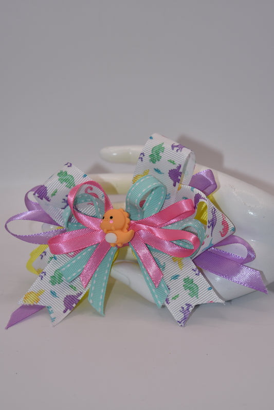Add some prehistoric flair to any hairstyle with Nana's Collection 27! This adorable bow features multicolor layers of quality ribbon in the shape of a dinosaur, making it a playful and unique accessory. Plus, the alligator wrapped clip ensures comfortable wear all day long. Rawr!