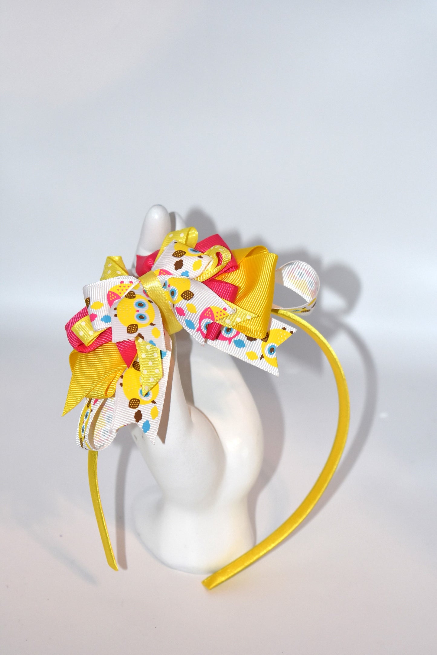 Hoot hoot! 🦉 This adorable satin-wrapped skinny headband is perfect for owl enthusiasts everywhere. Featuring a charming owl motif with pretty layers of pink and yellow ribbon, it's the ultimate accessory for adding a touch of whimsy to your look. The perfectly coordinated colors and soft satin finish make it both stylish and comfortable to wear all day long. Whether you're a devoted owl lover or just looking for something cute and quirky, this headband delivers charm in spades! 💛🩷